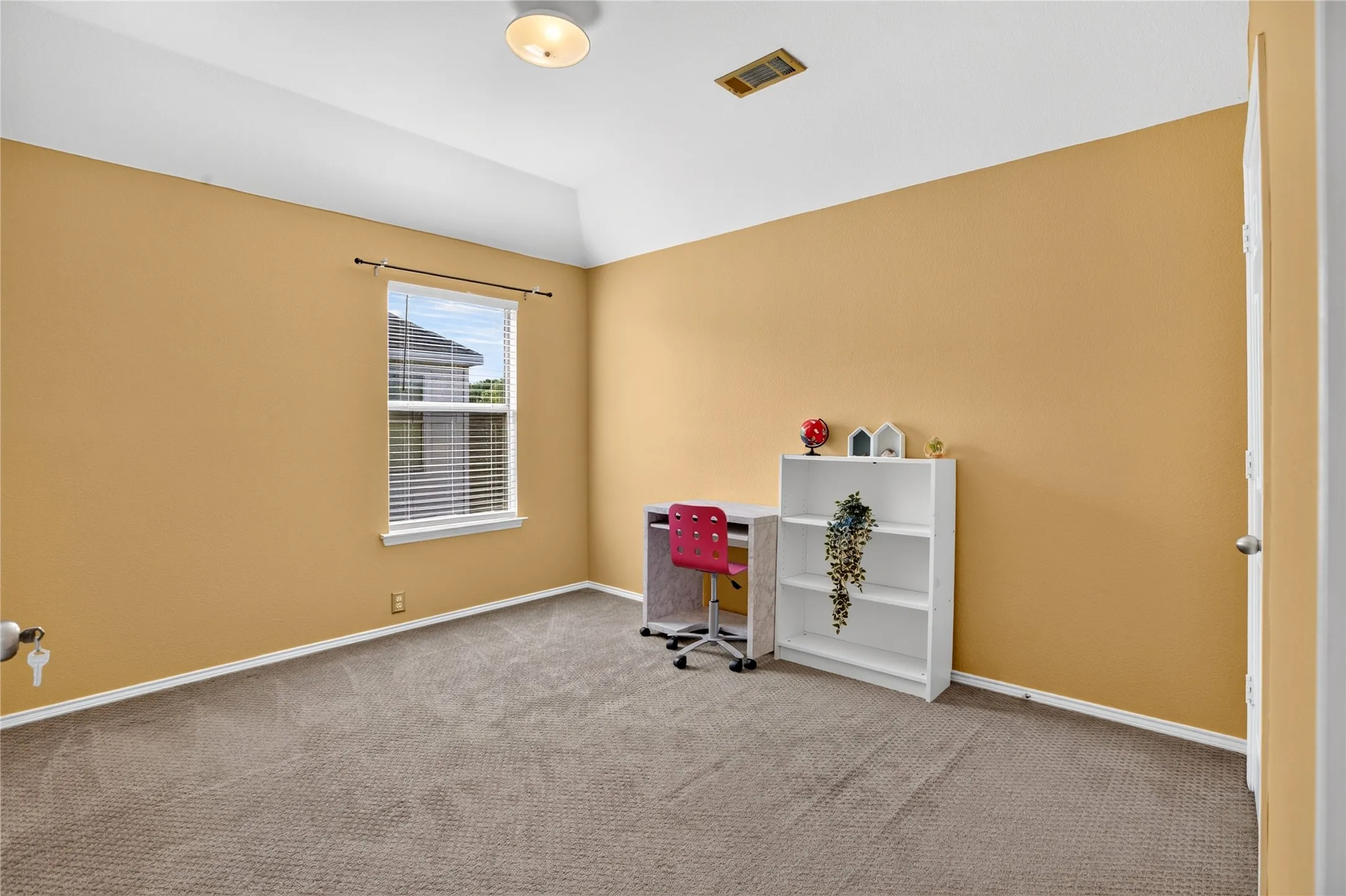 Vaulted ceiling, recessed window with blinds, wall-to-wall carpeting, and a flush-mount ceiling light fixture