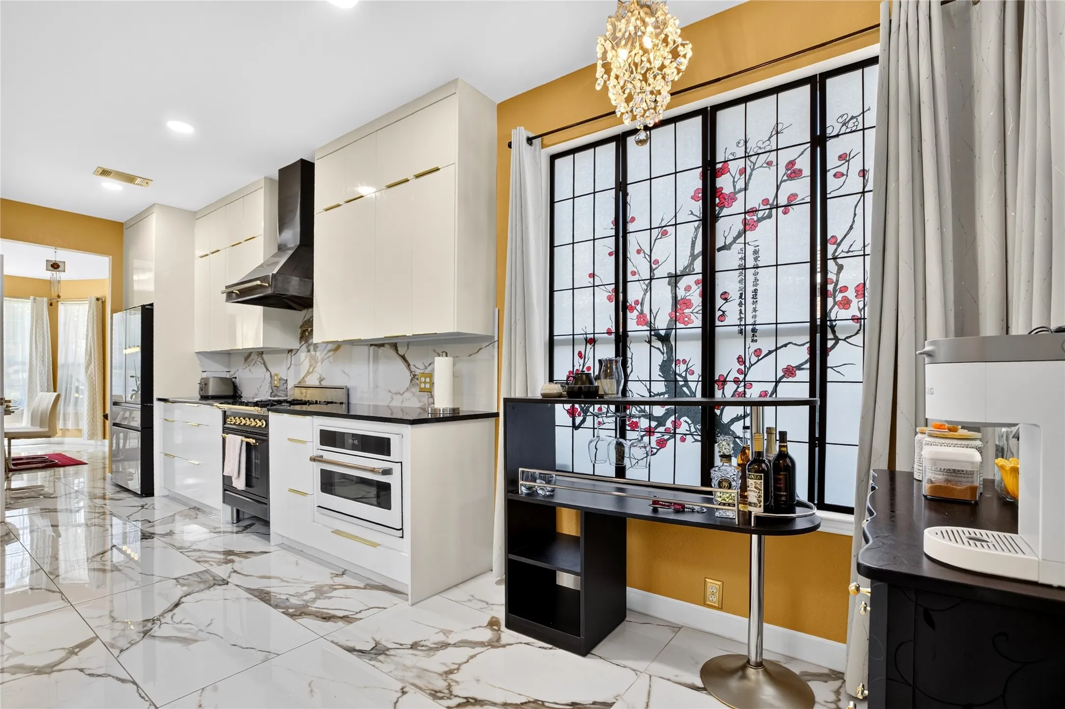 Gourmet kitchen featuring high-gloss cabinetry, stainless steel appliances, and a decorative window
