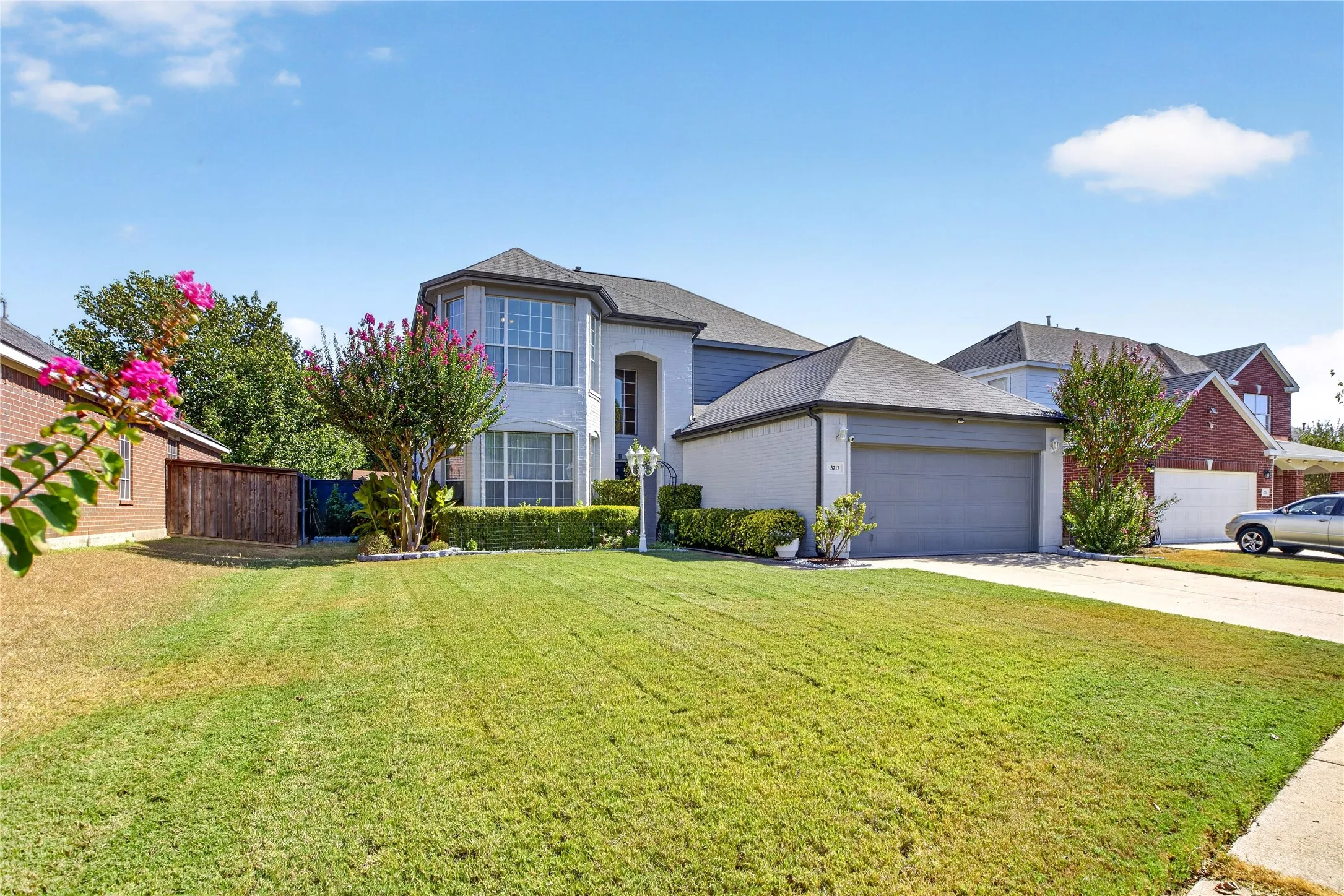 Two-story residence featuring a bay window, attached garage, and a concrete driveway