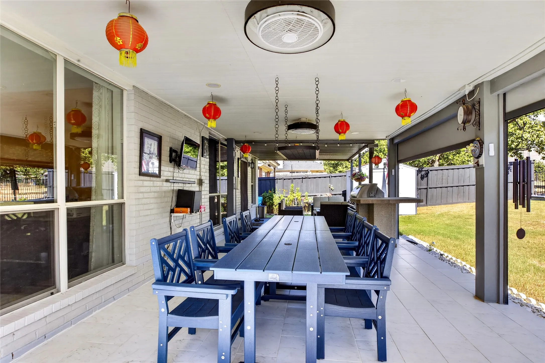 Covered patio with integrated outdoor kitchen, ceiling fans, and tiled flooring
