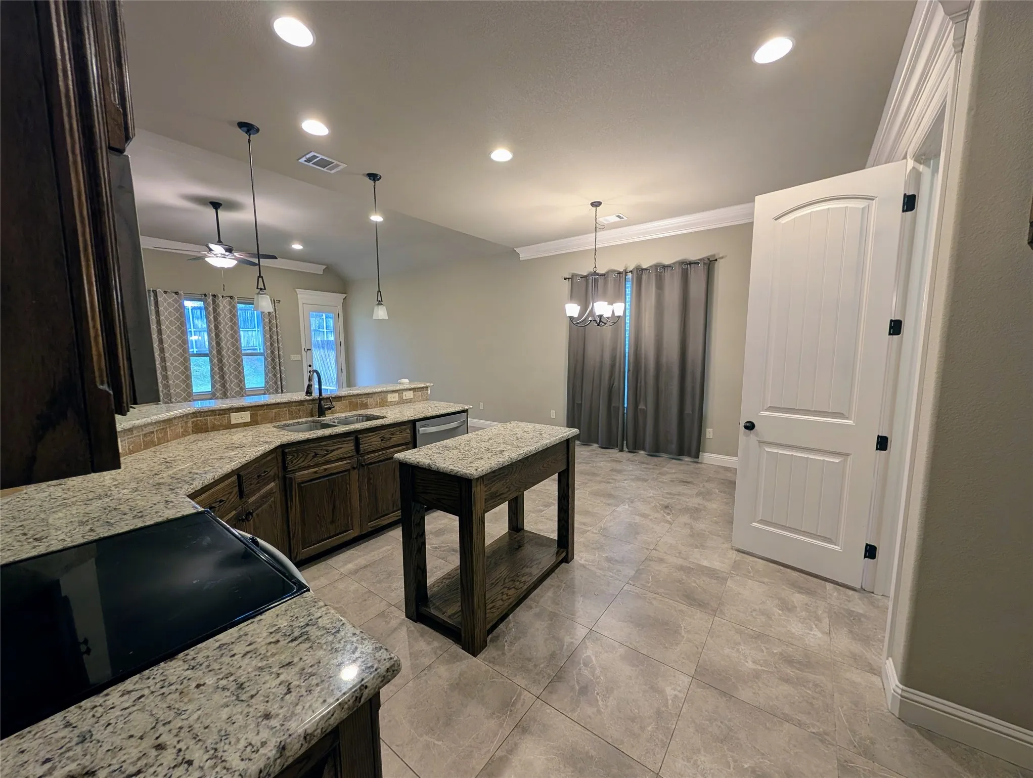 Kitchen featuring granite countertops, a built-in cooktop, and wood-finish cabinetry