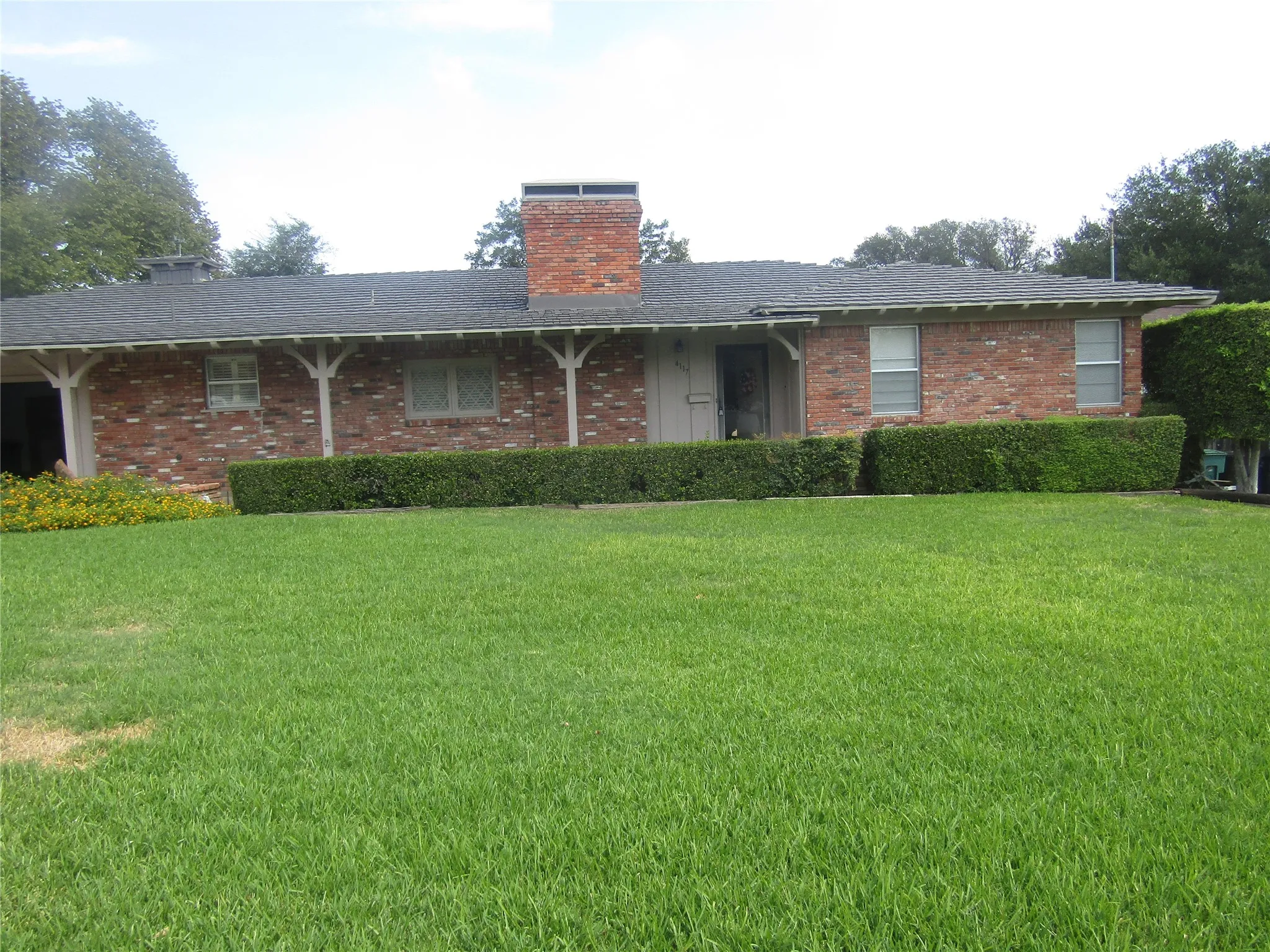 Red brick exterior with a large front lawn