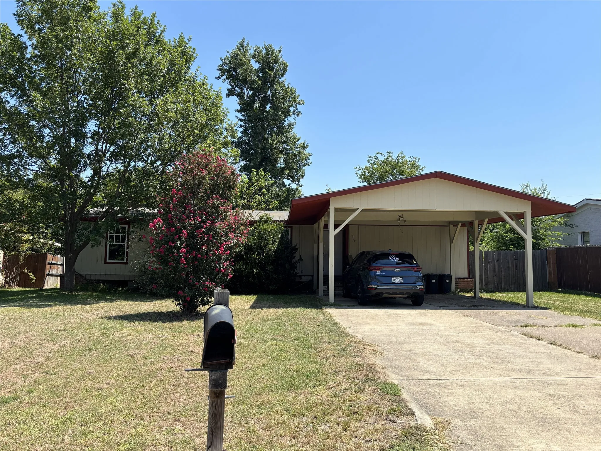 Expansive front yard with mature trees and established landscaping