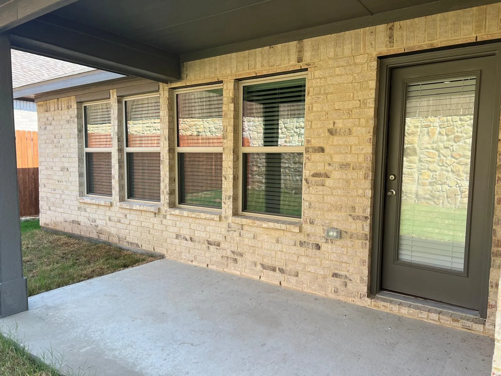 Entrance to property with a patio and brick siding