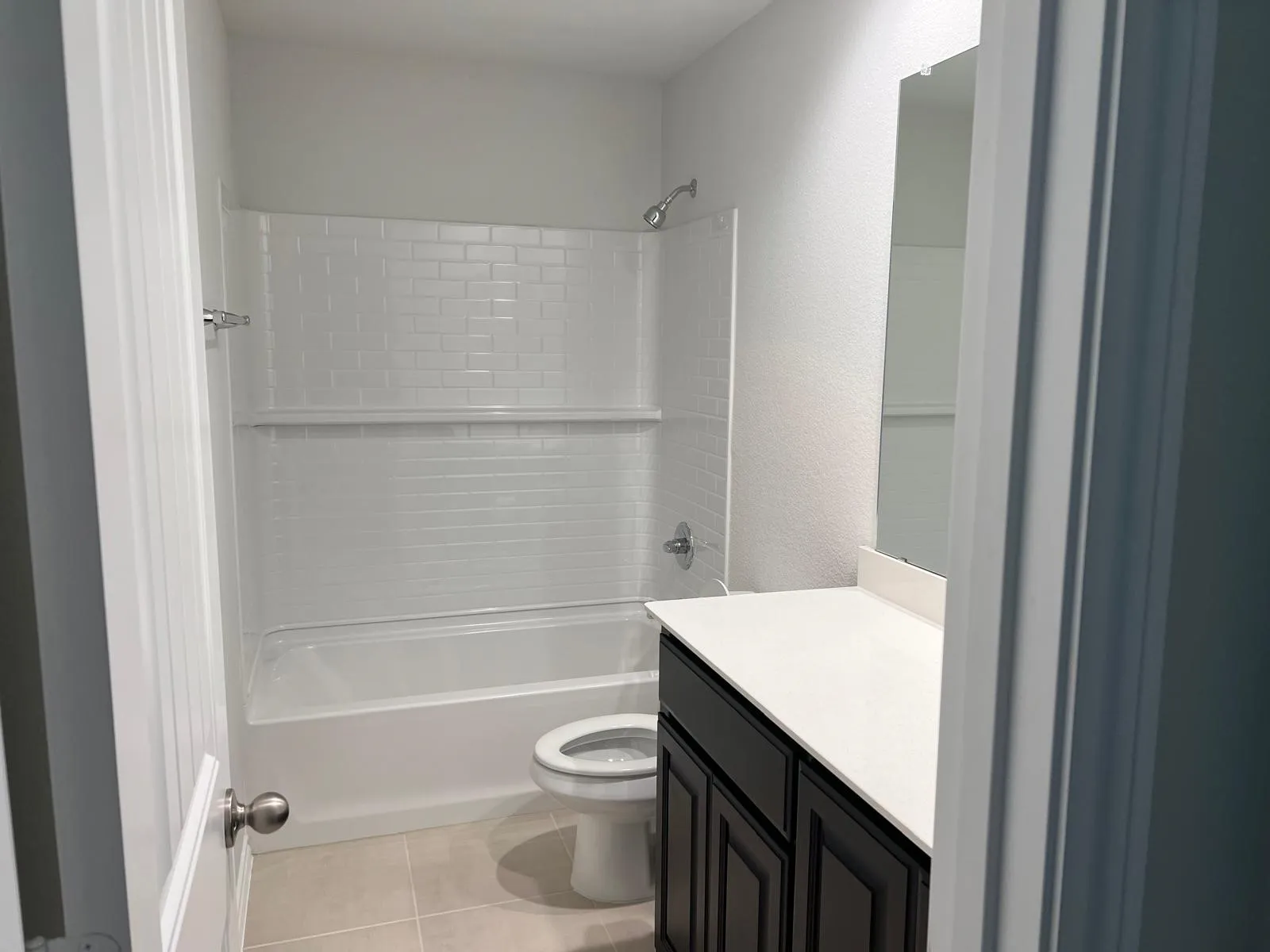 Bathroom featuring bathtub / shower combination, light tile patterned floors, and vanity