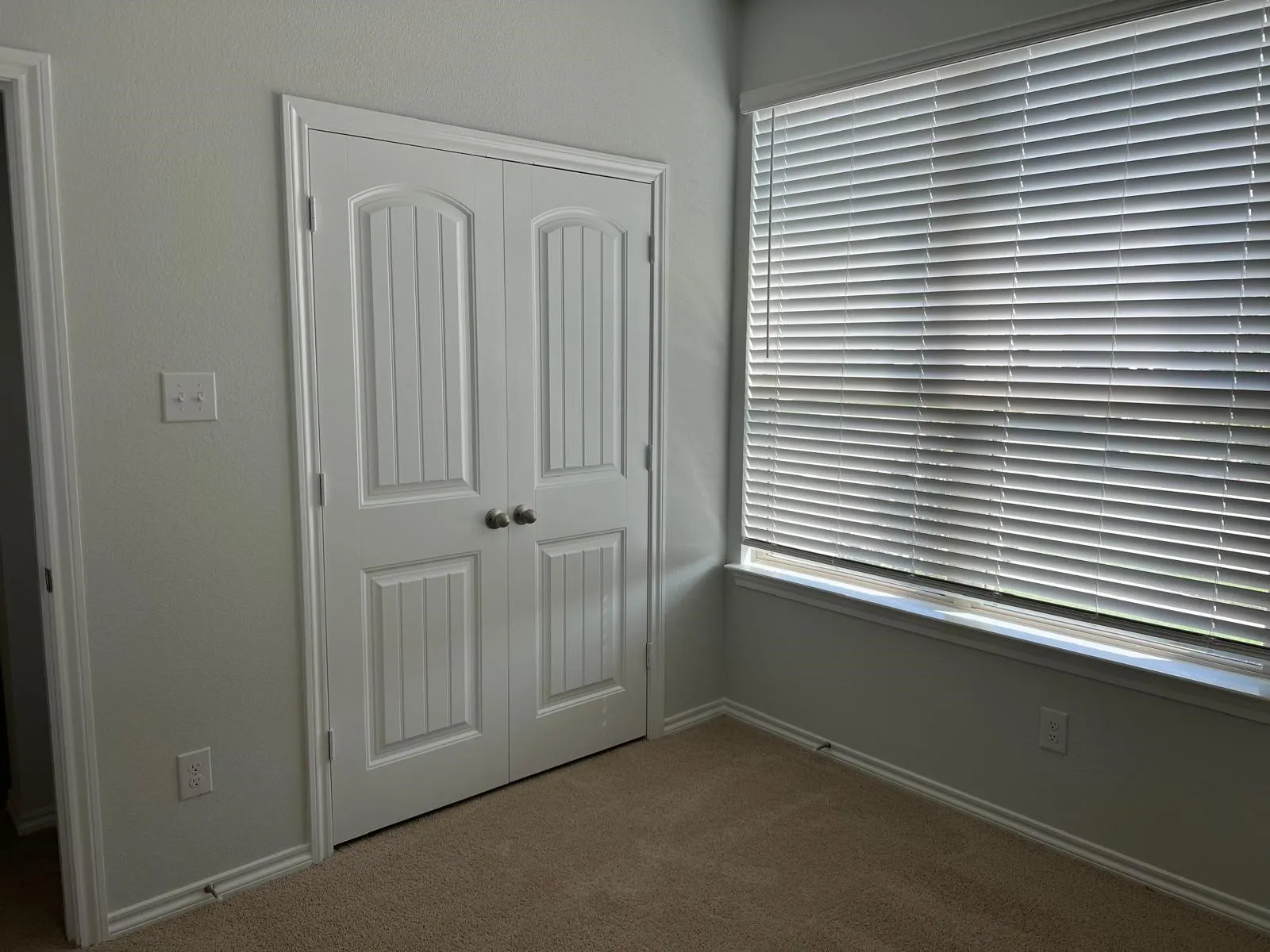 Unfurnished bedroom featuring dark colored carpet, multiple windows, and a closet