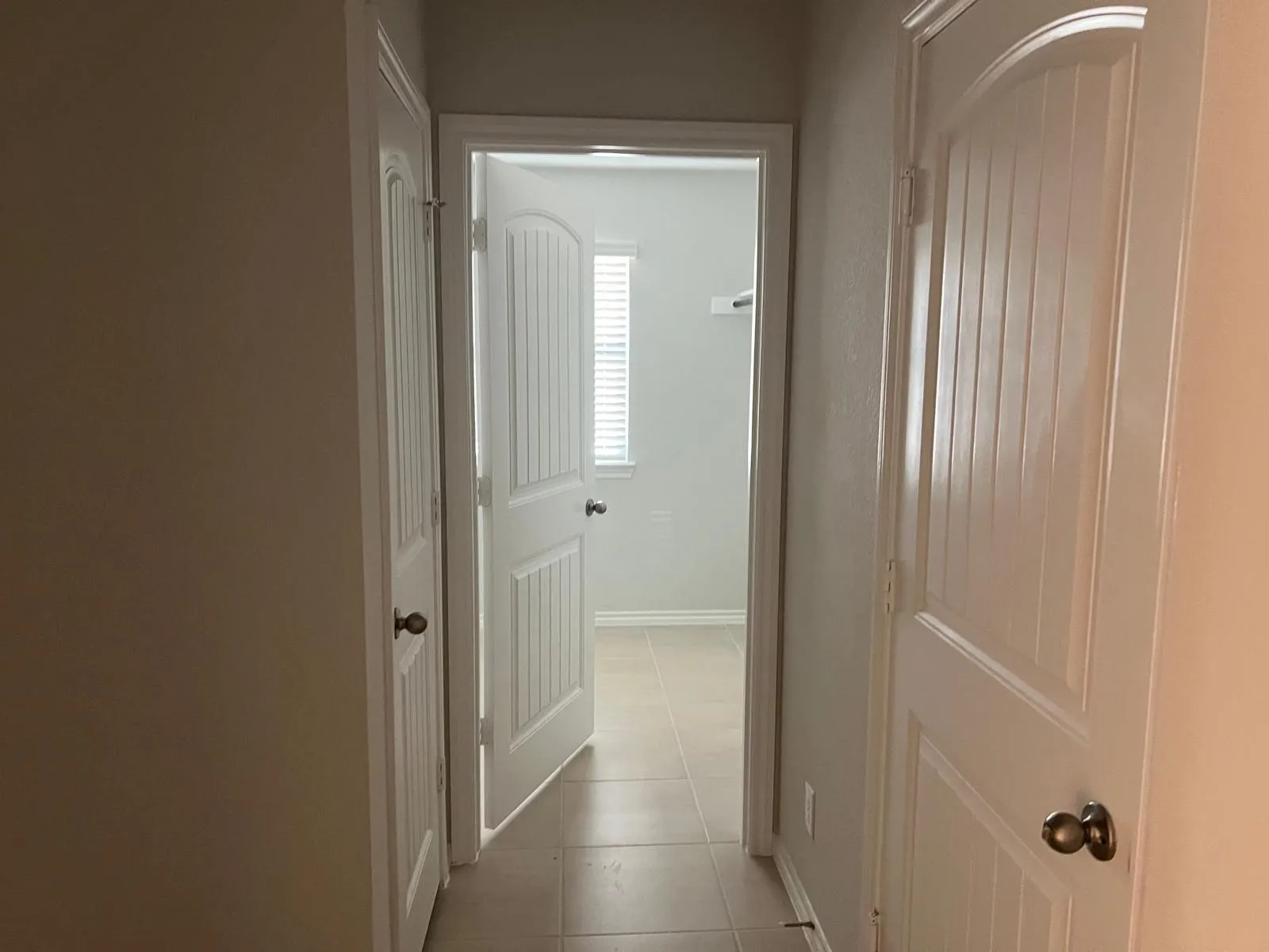 Hallway featuring light tile patterned flooring and baseboards