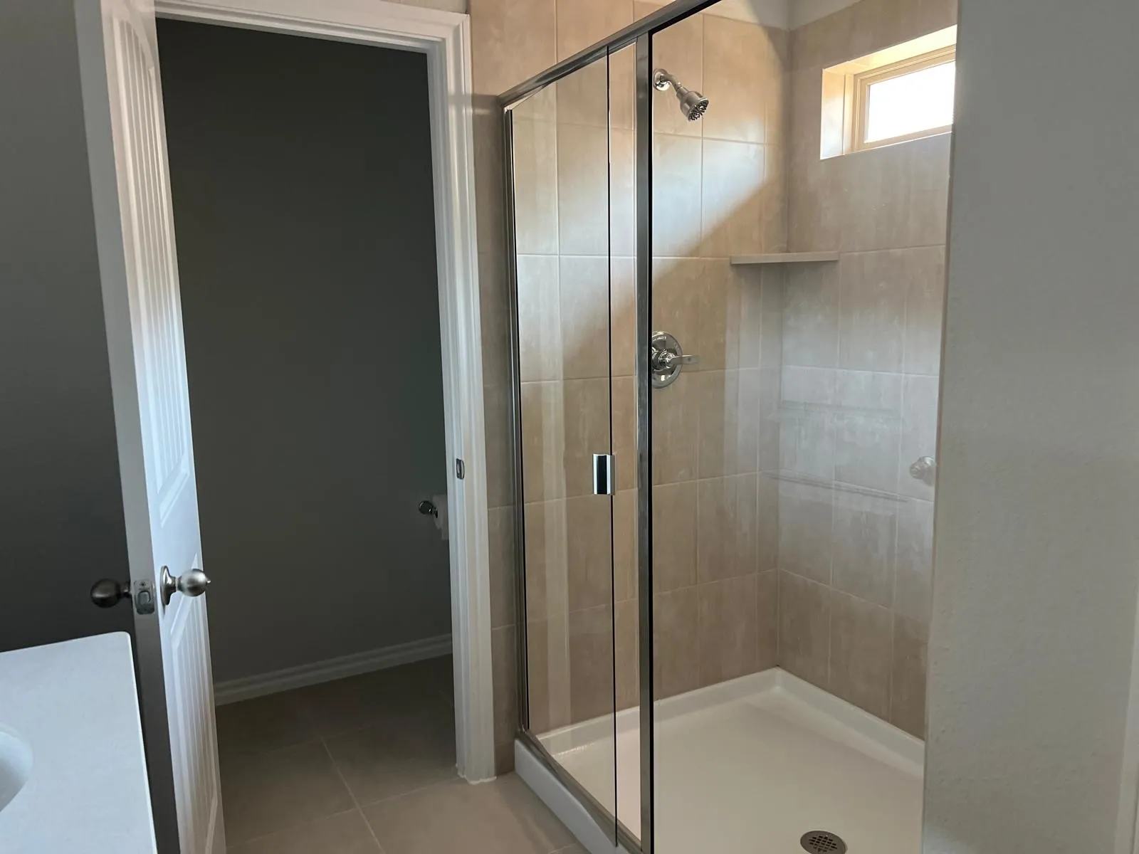 Bathroom with a shower stall, light tile patterned floors, and vanity