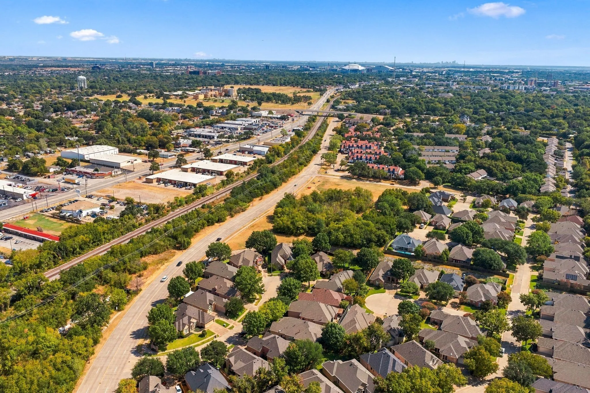 Residential properties with mature trees, commercial buildings, and roadways