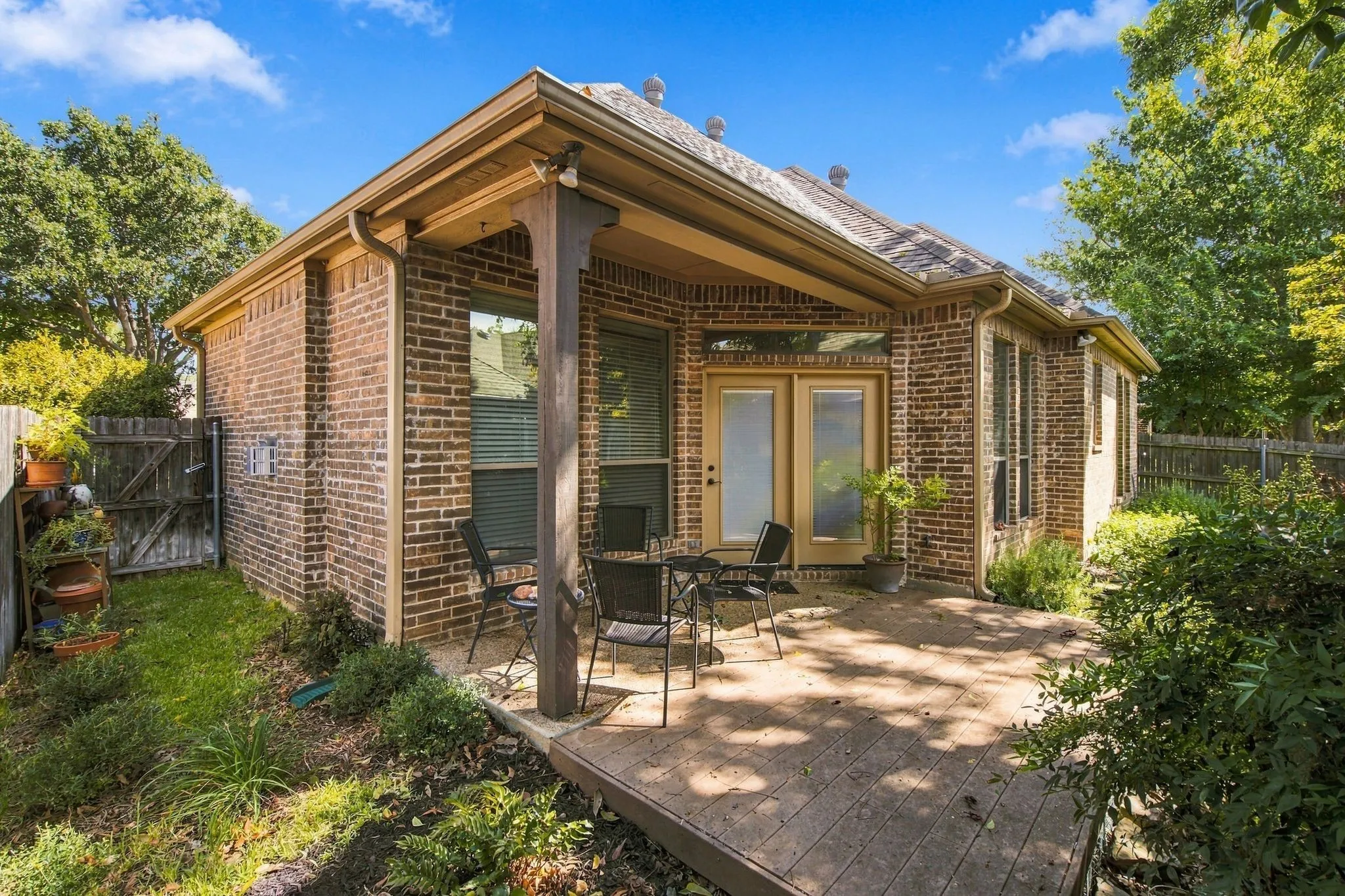 Brick exterior with a covered patio and a wood-finish fence