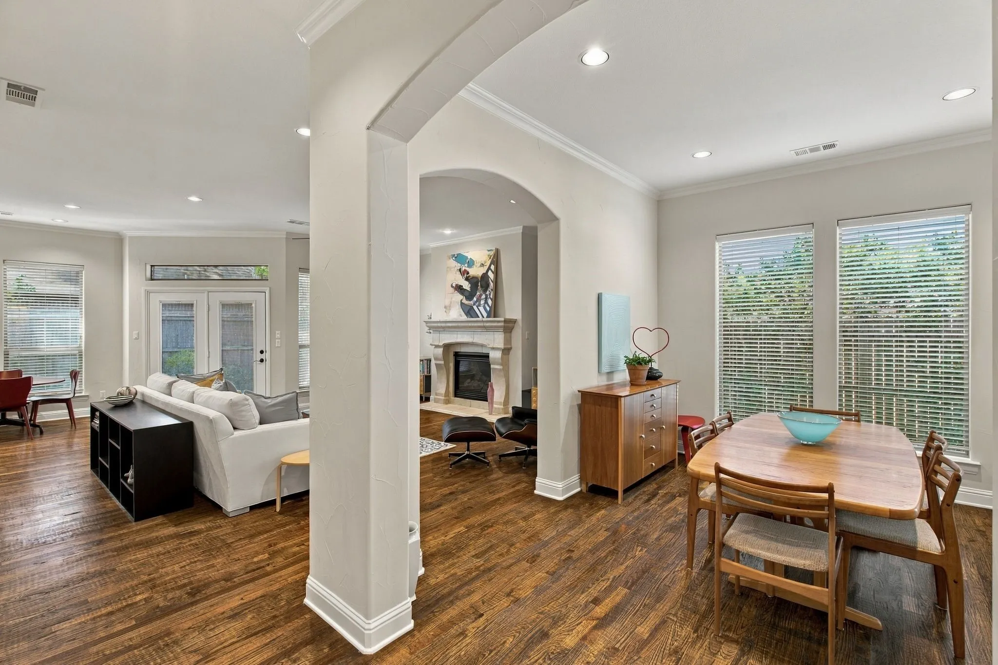 Open-concept living space featuring wood-finish flooring, recessed lighting, and multiple windows