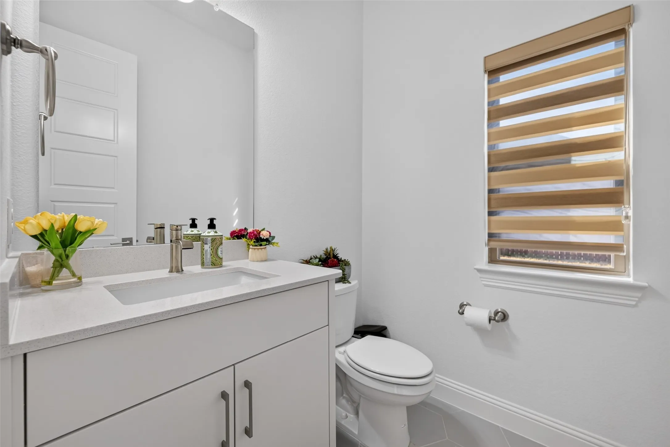Modern vanity with an integrated sink, quartz-finish countertop, and brushed nickel faucet
