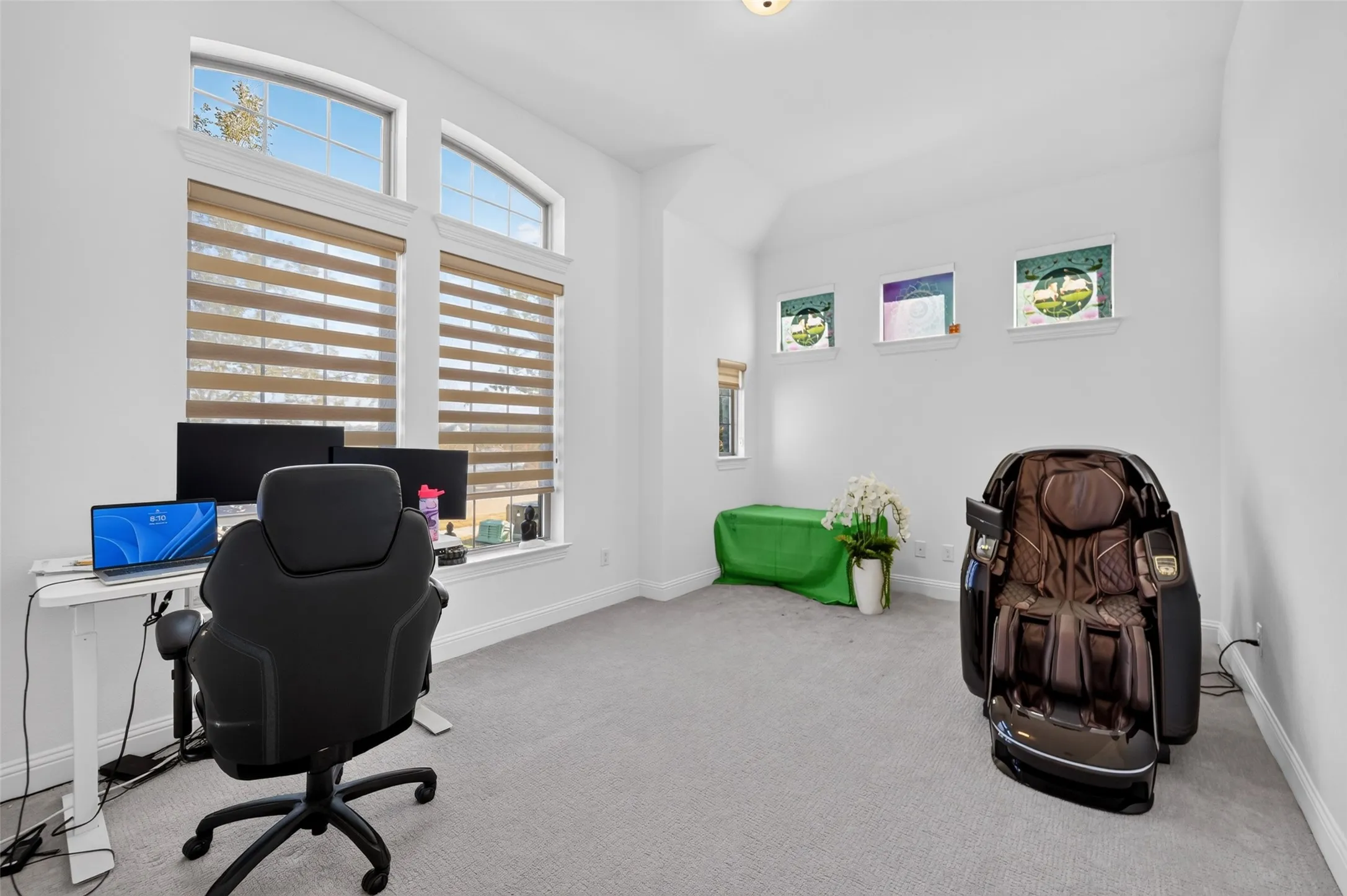 Vaulted ceiling, arched transom windows, two primary windows with blinds, recessed lighting, and carpet flooring