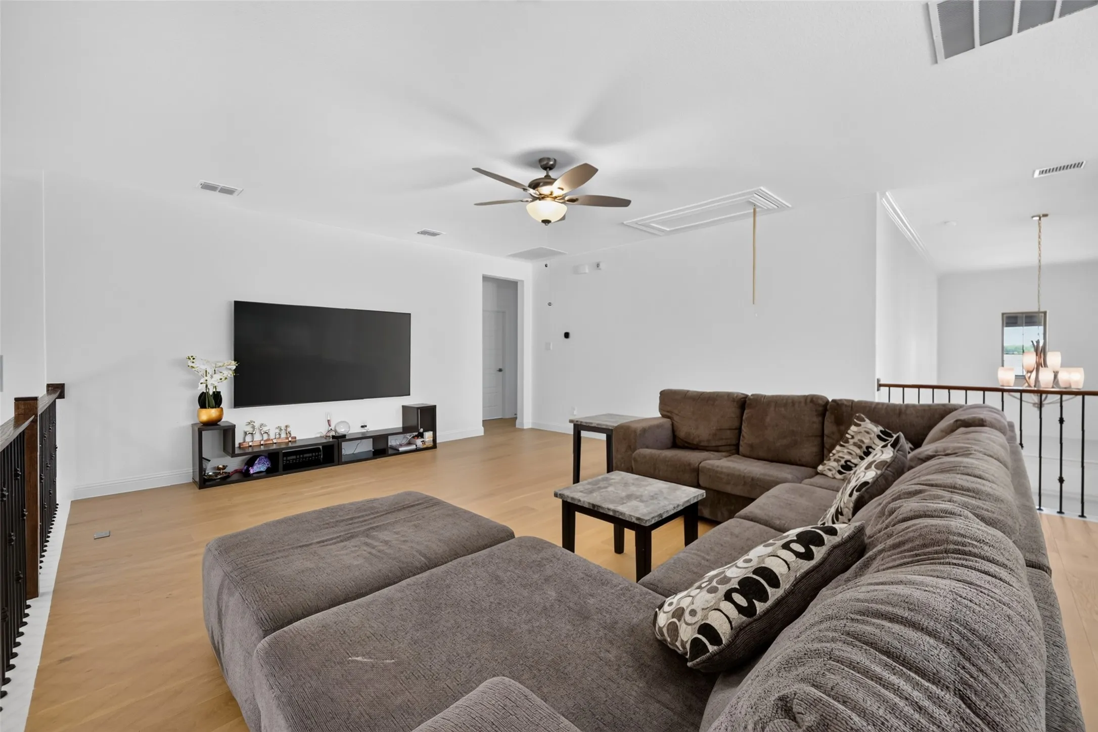 Wood-finish flooring throughout, with a ceiling fan and recessed lighting