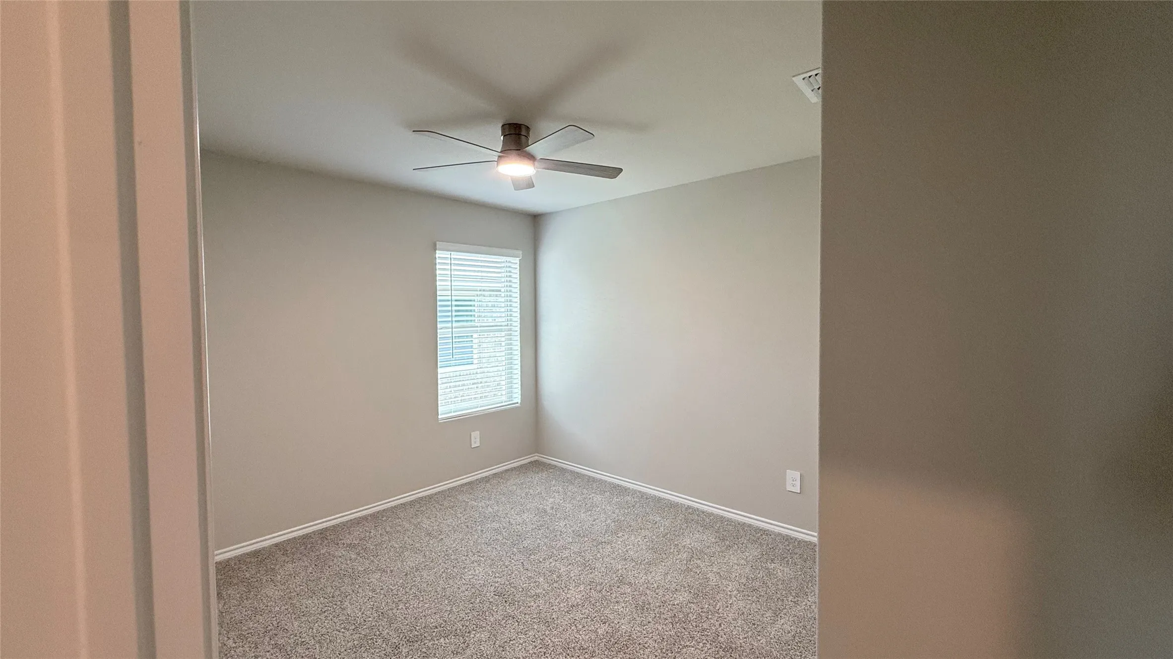 Recessed ceiling fan with integrated lighting, neutral wall paint, carpet flooring, and a single window with blinds