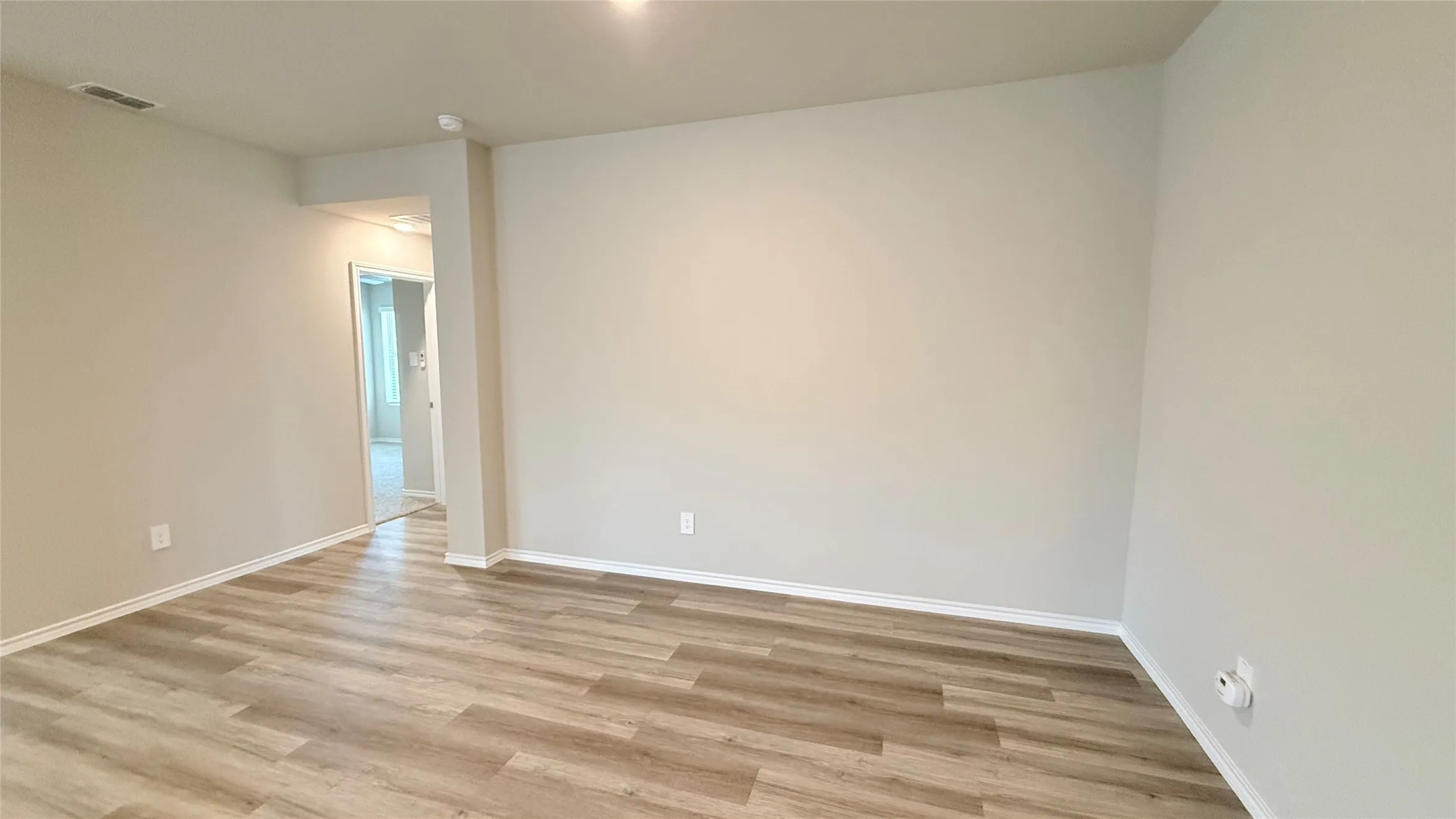 Wood-finish flooring with neutral wall tones and white trim