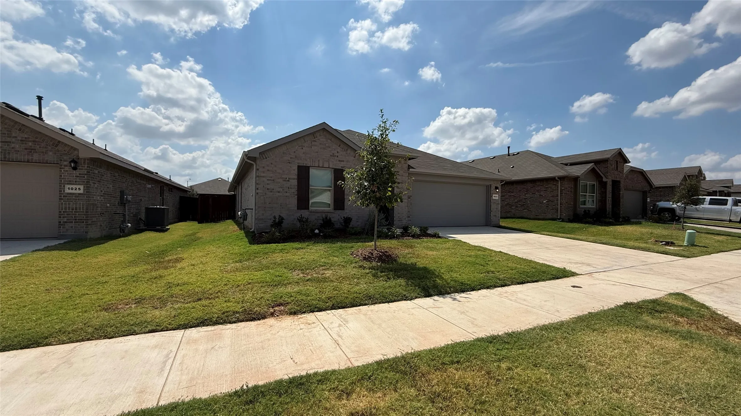 Brick exterior with a single-car garage and concrete driveway