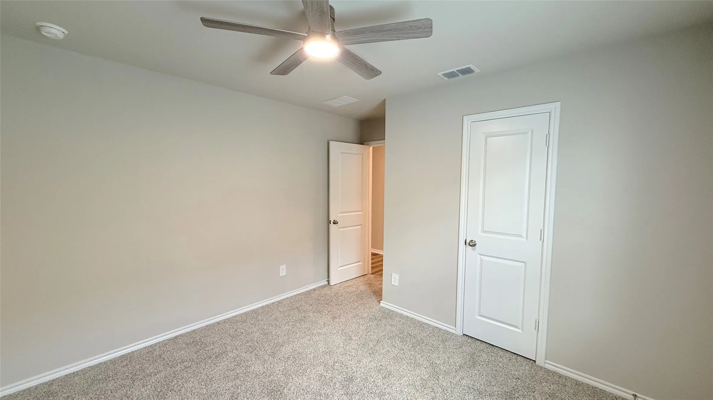 Neutral-toned walls complement plush carpeting