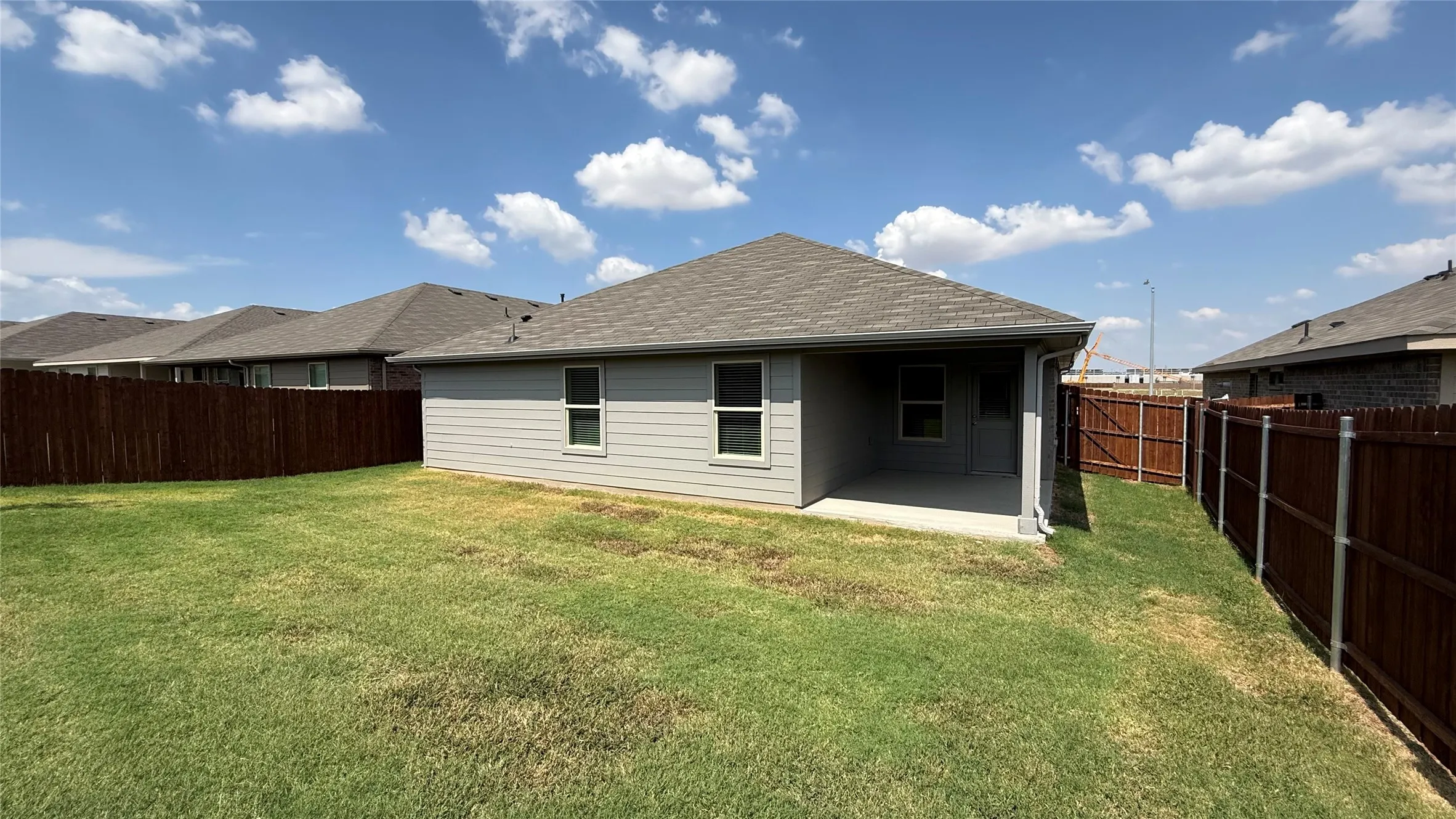 Fenced backyard featuring a covered patio, shingled roof, and horizontal siding
