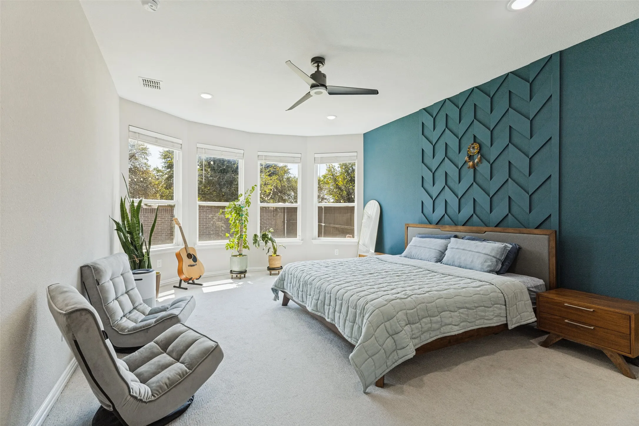 Curved wall with a bay window, recessed lighting, and a ceiling fan
