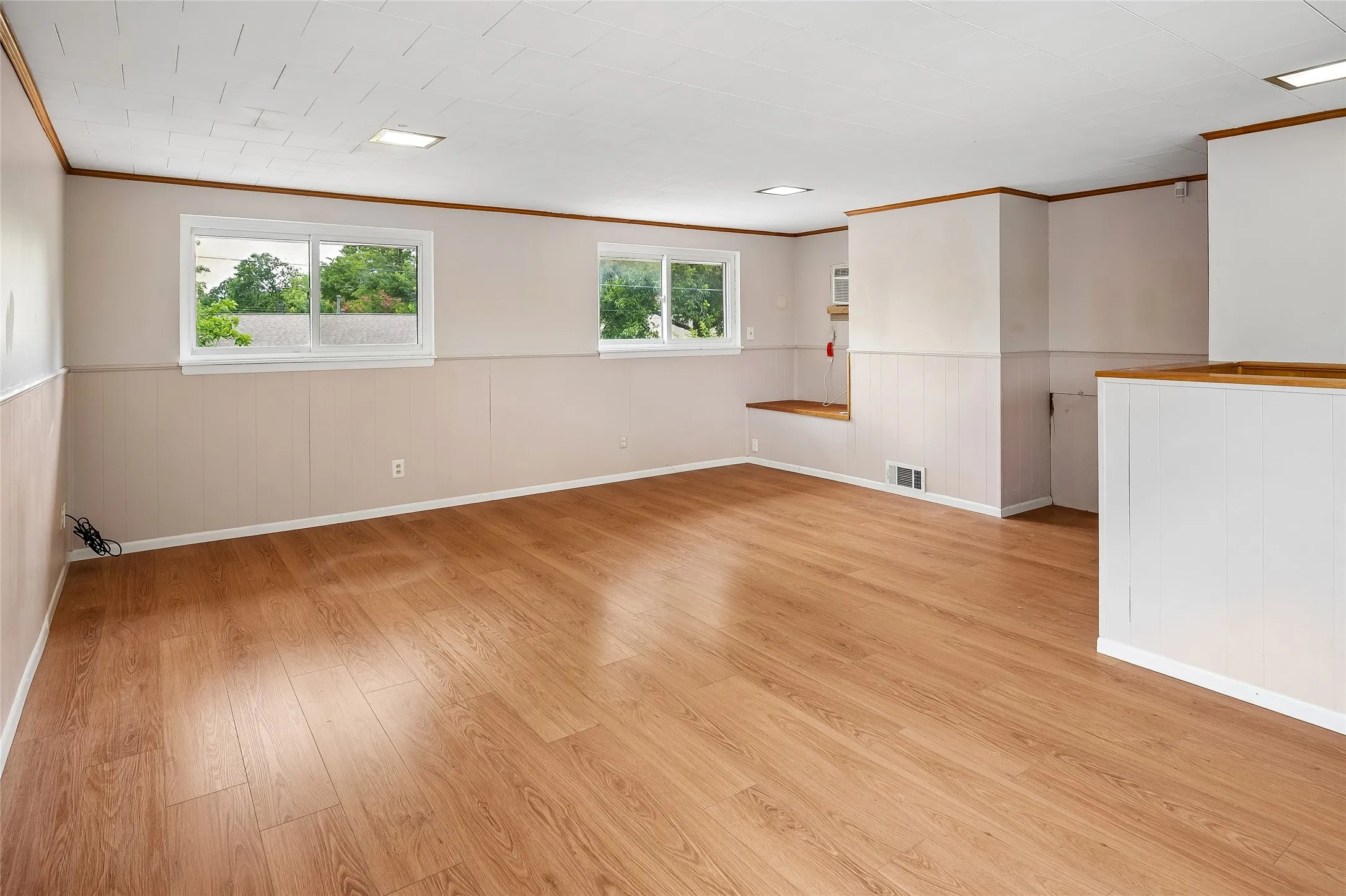 Upstairs 4th bedroom where wide plank wood-look laminate flooring continues.