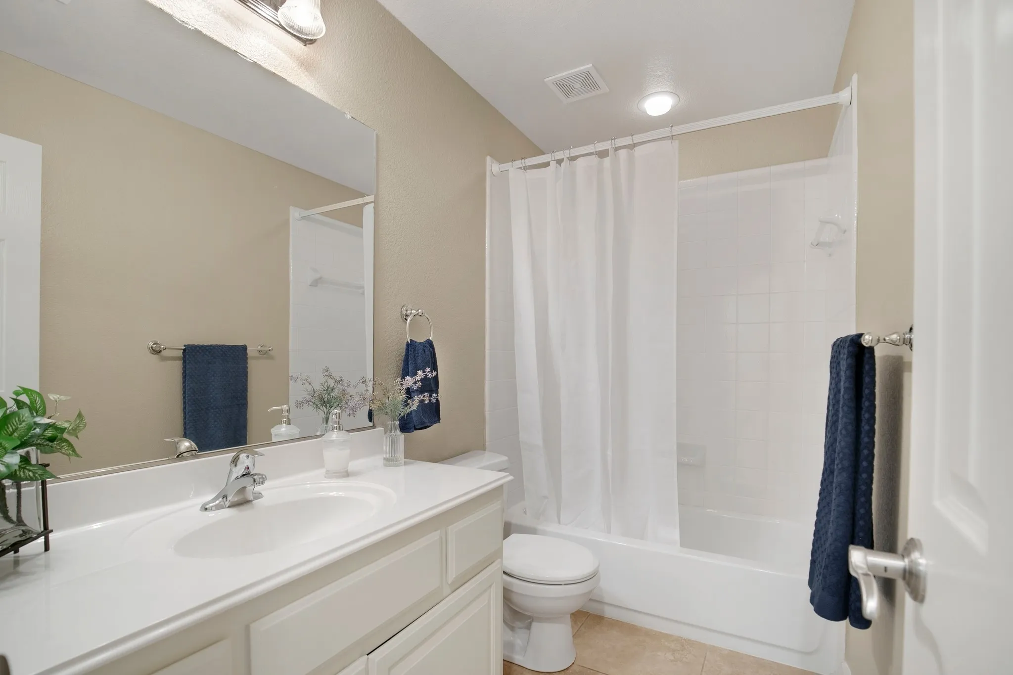 Vanity with integrated sink, chrome faucet, and expansive mirror