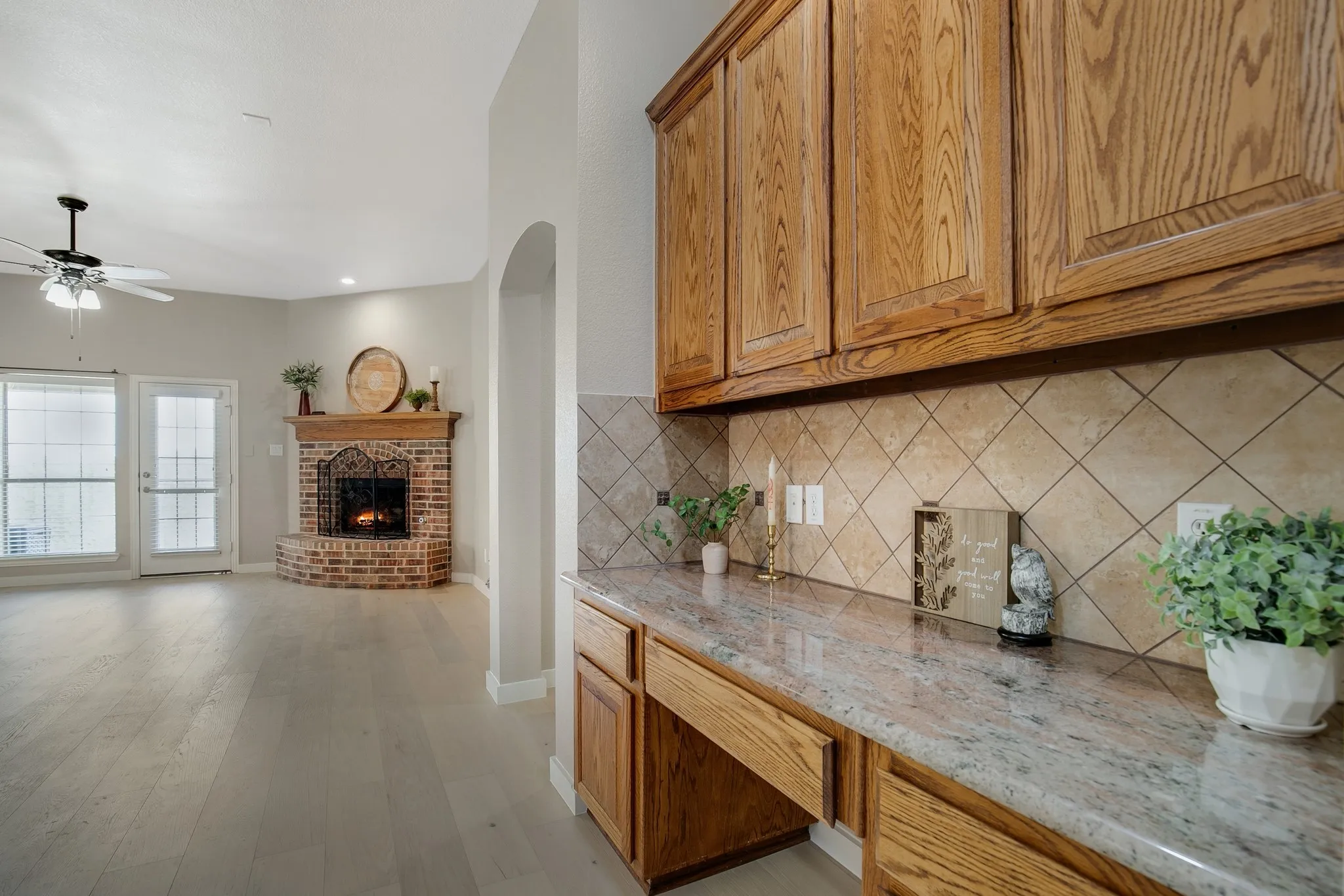 Built-in desk area with wood cabinetry and stone-look countertop