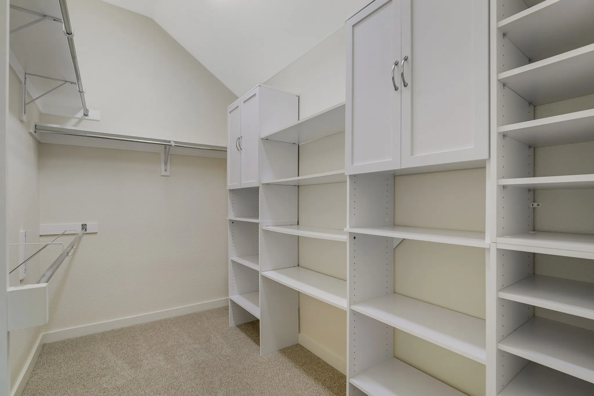 Built-in shelving, integrated cabinetry with hardware, and metal hanging rods