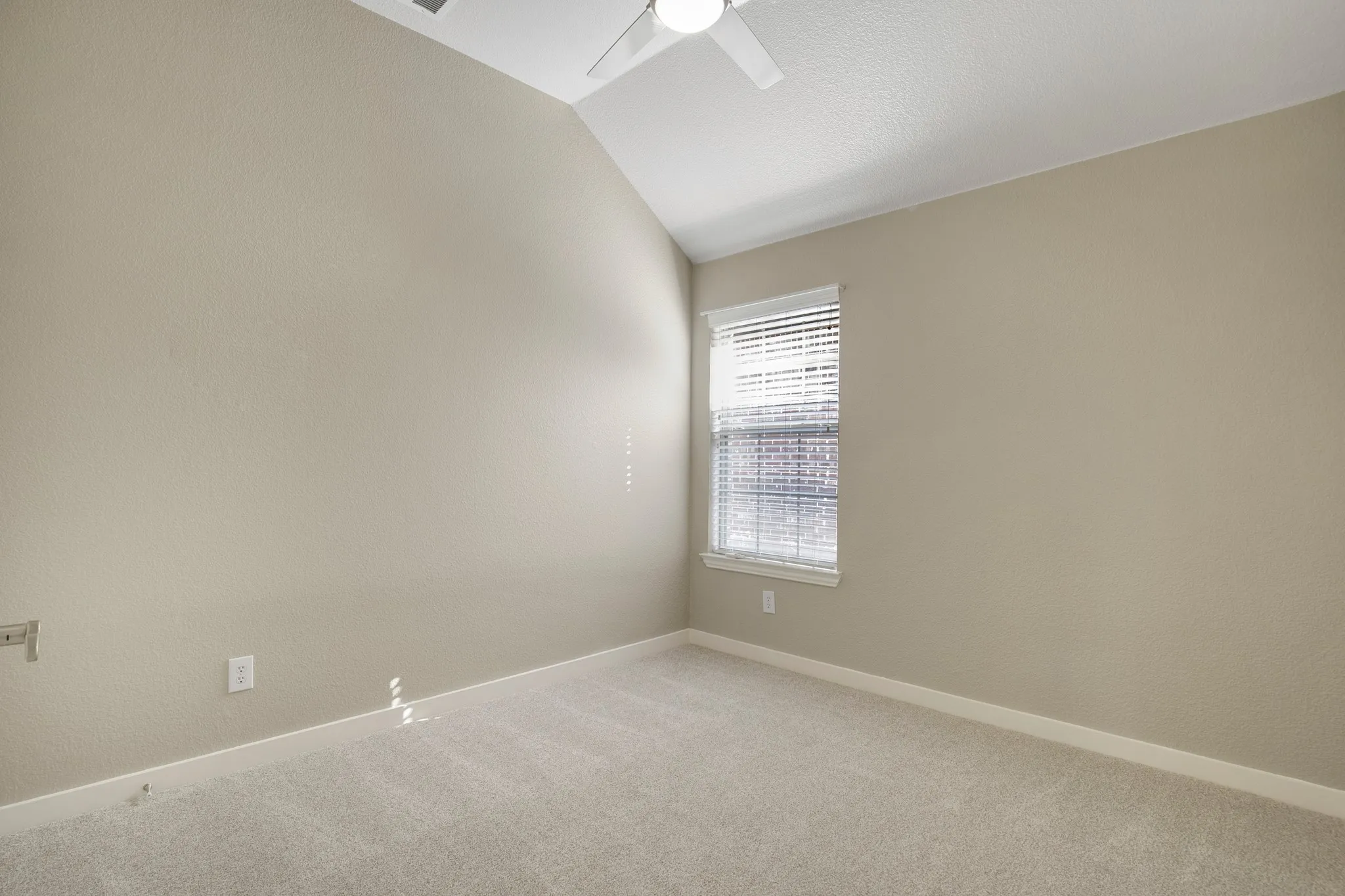Vaulted ceiling, carpet flooring, window with blinds, and a ceiling fan