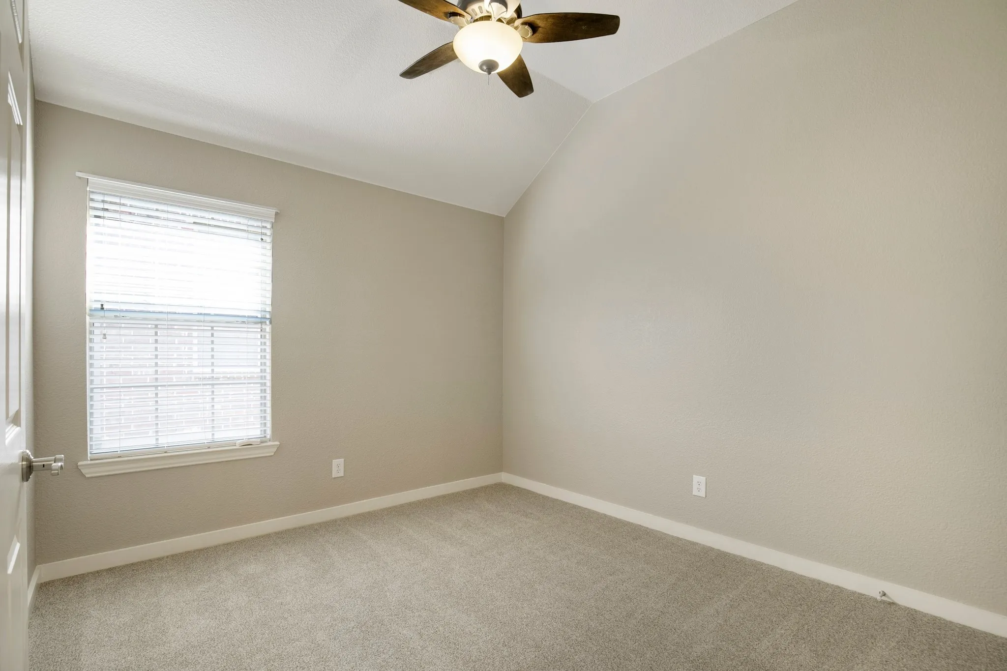 Vaulted ceiling with a ceiling fan, neutral carpet, and a window with blinds