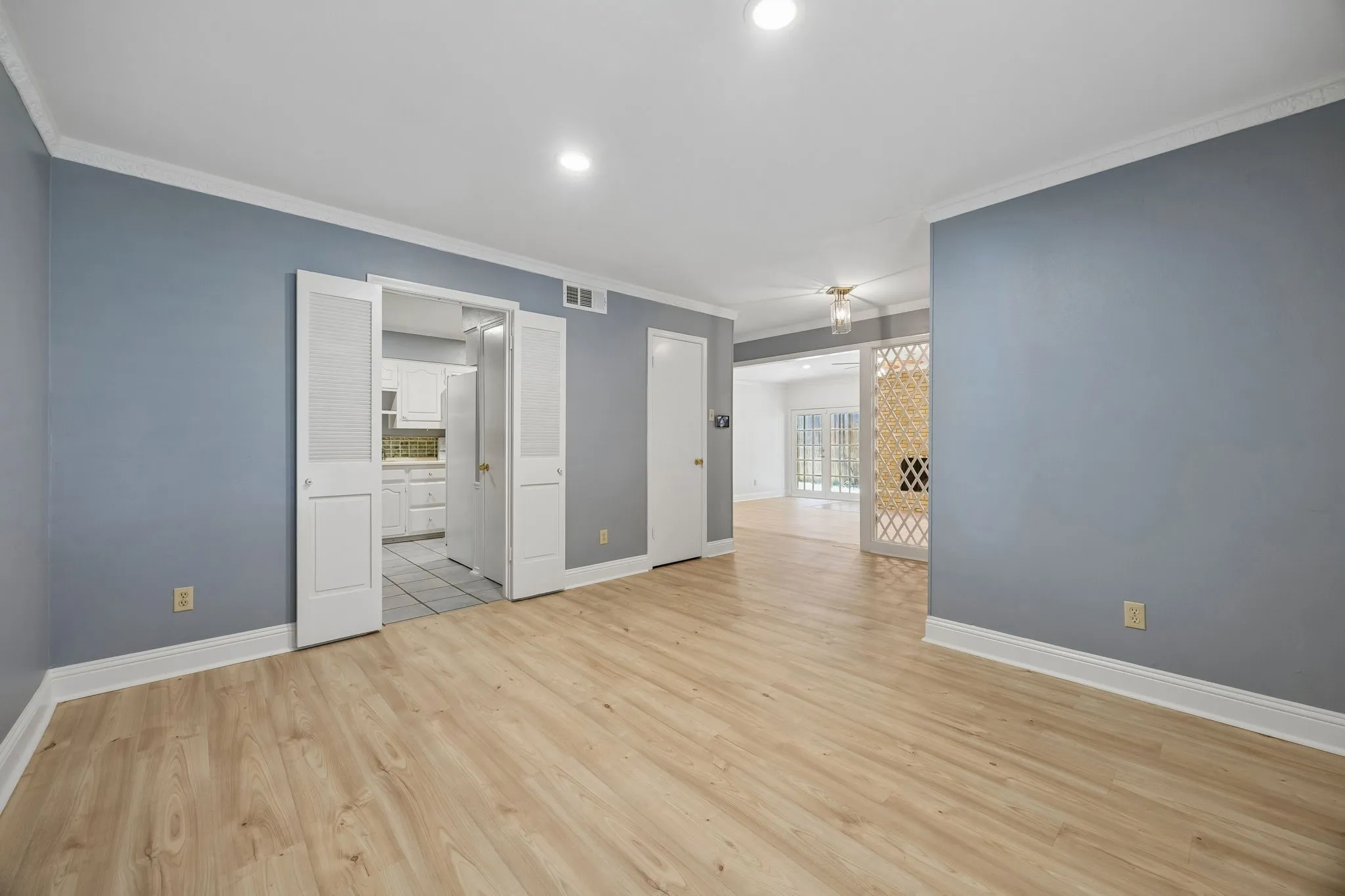 Dining room with wood-look flooring and an open connection to the adjoining living space and kitchen.