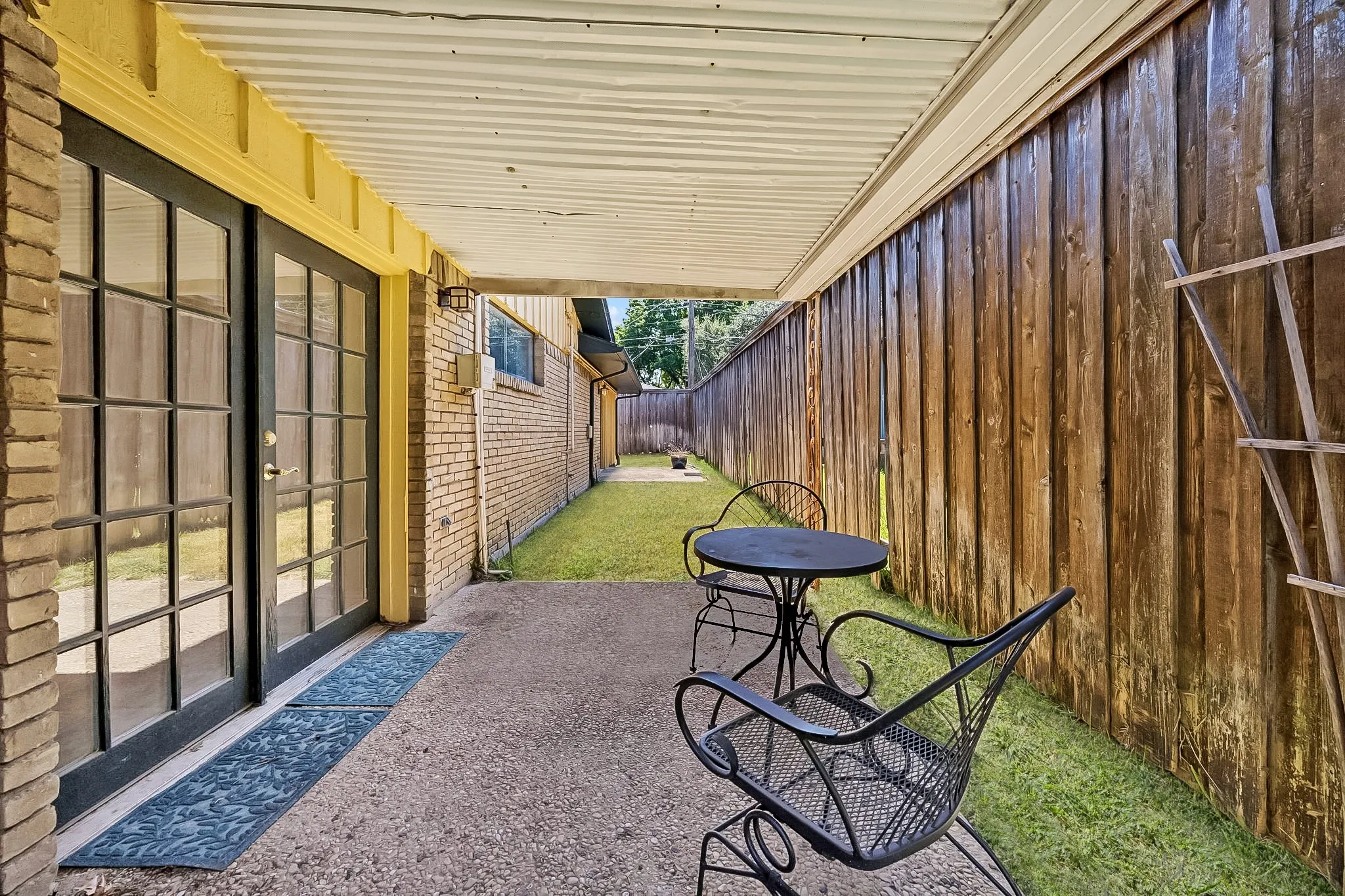 Covered patio with French door access, offering a shaded outdoor space overlooking the backyard.