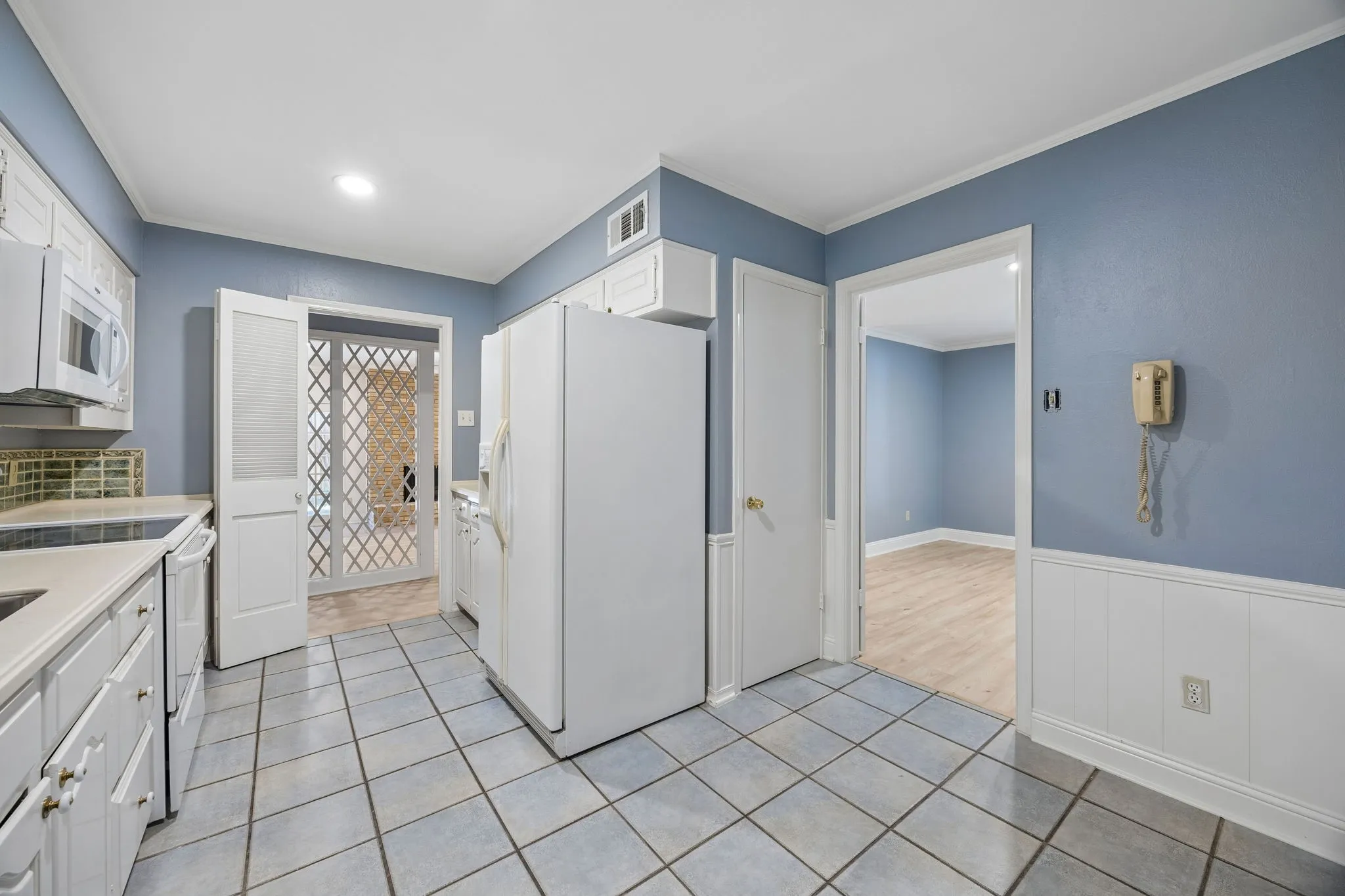 Bright kitchen with white cabinetry, generous storage, and easy access to the adjoining dining area.