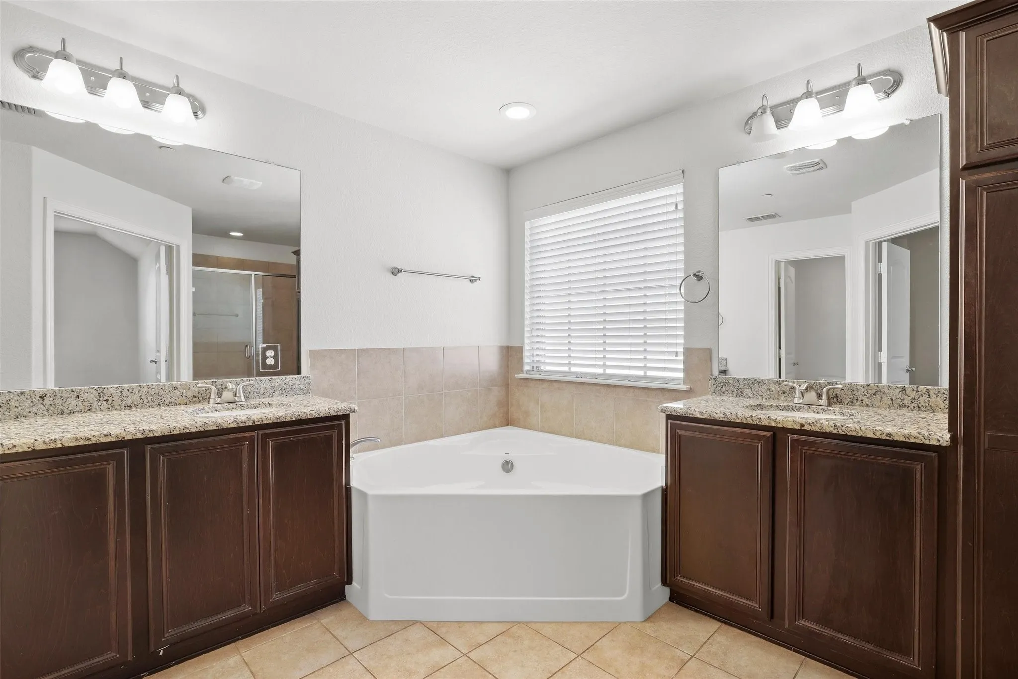 The primary bath also ofers granite counter-tops, a separate tub and shower.