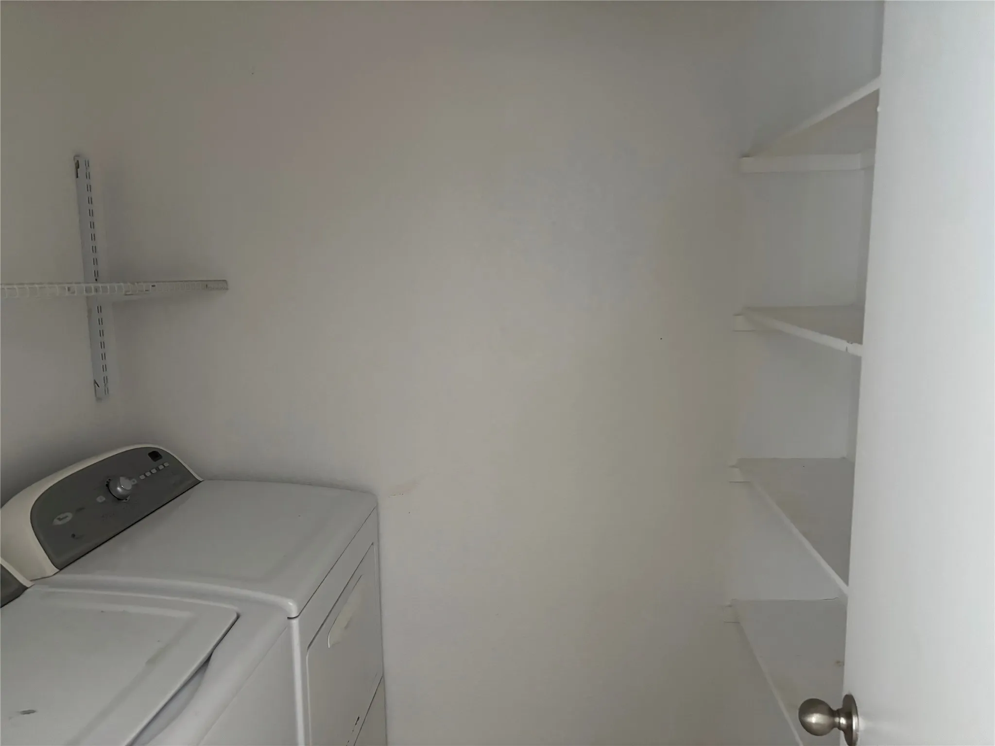 Laundry area with white walls and built-in shelving