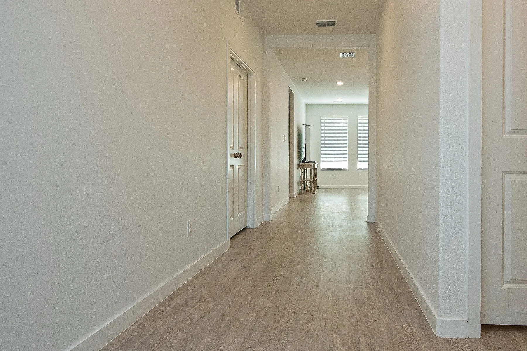 Hallway featuring wood-finish flooring, white walls, and recessed lighting