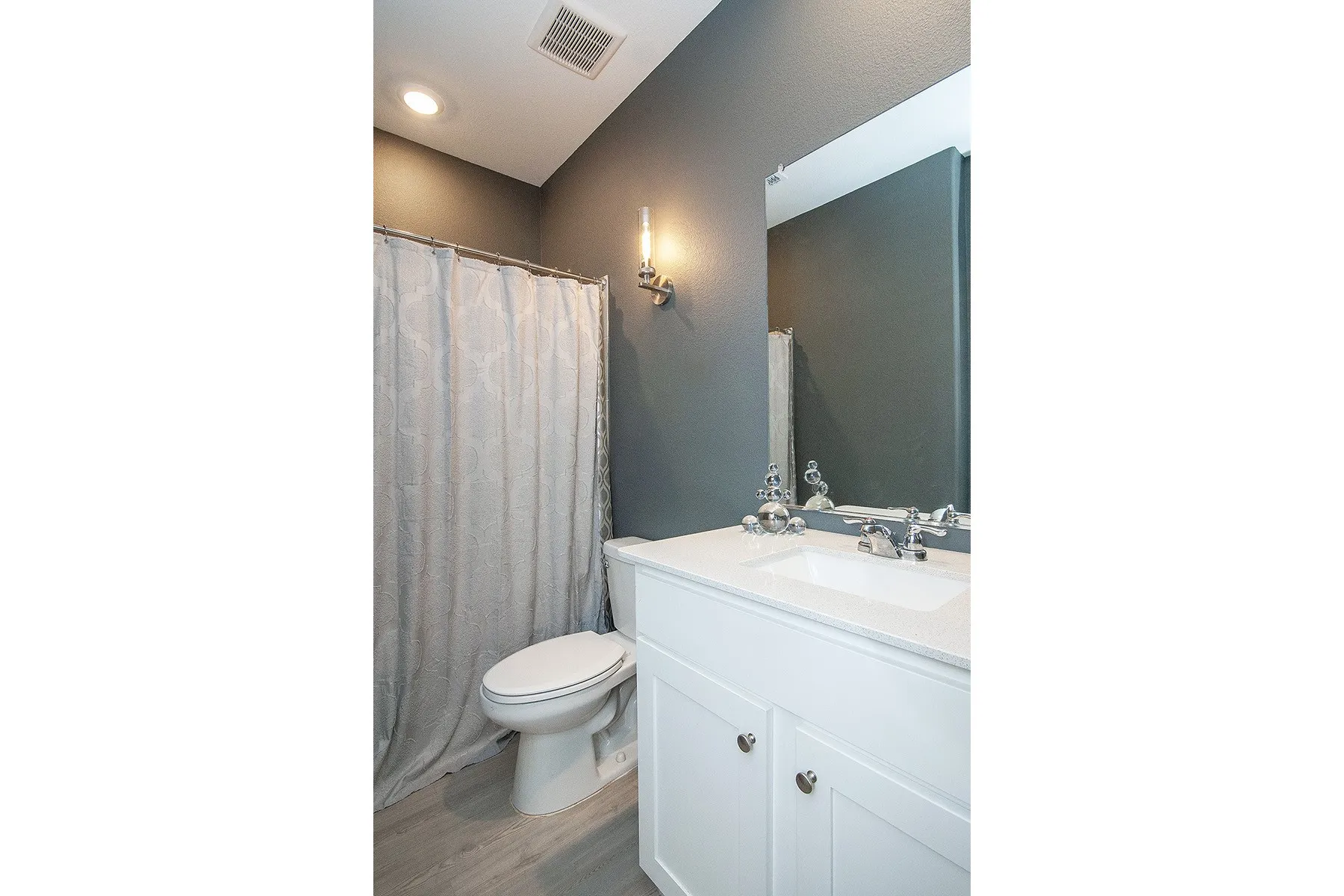 White vanity with an integrated sink, polished chrome faucet, and overhead mirror