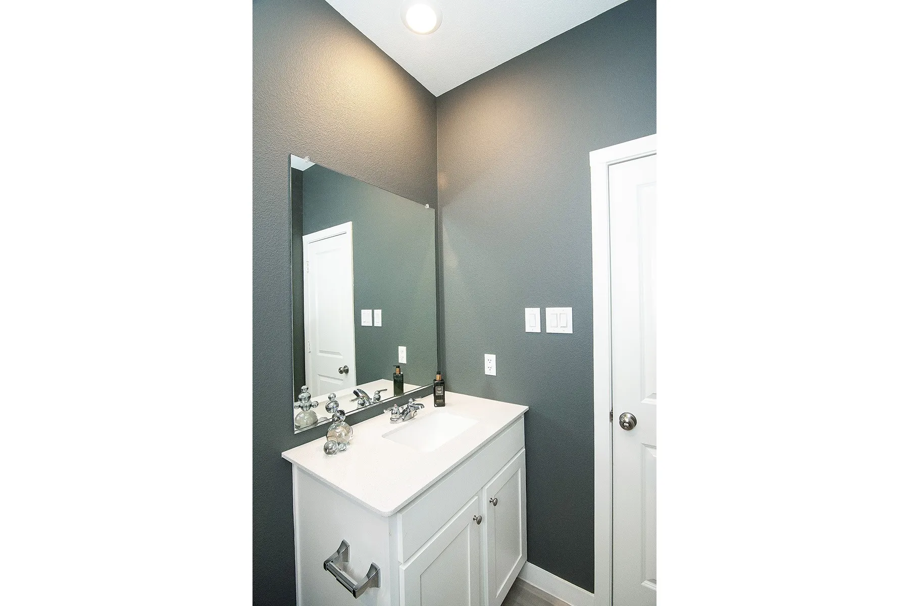 White vanity with cabinet storage, integrated sink, and white countertop