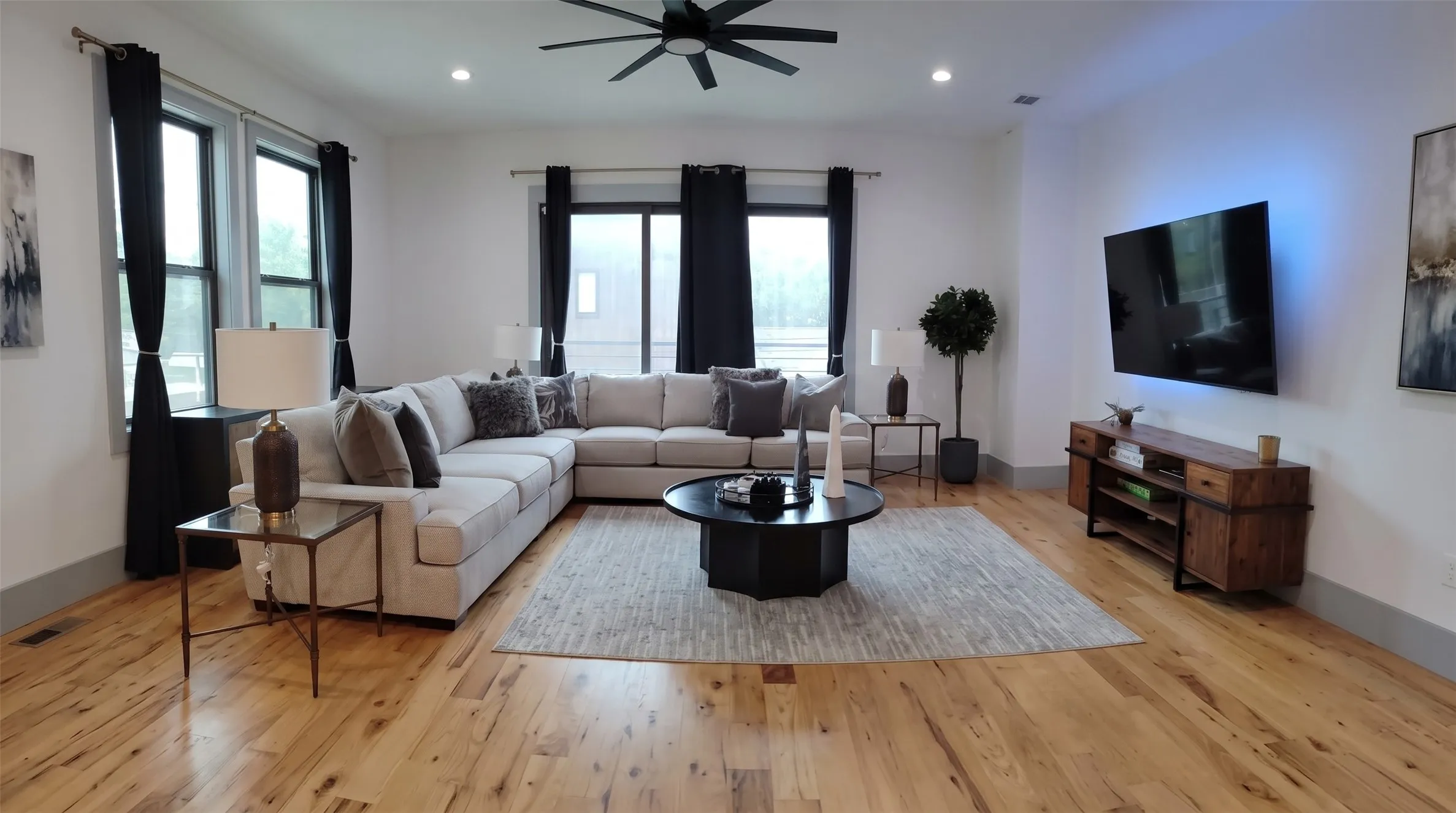 Spacious living area featuring wood-finish flooring, recessed lighting, and a ceiling fan