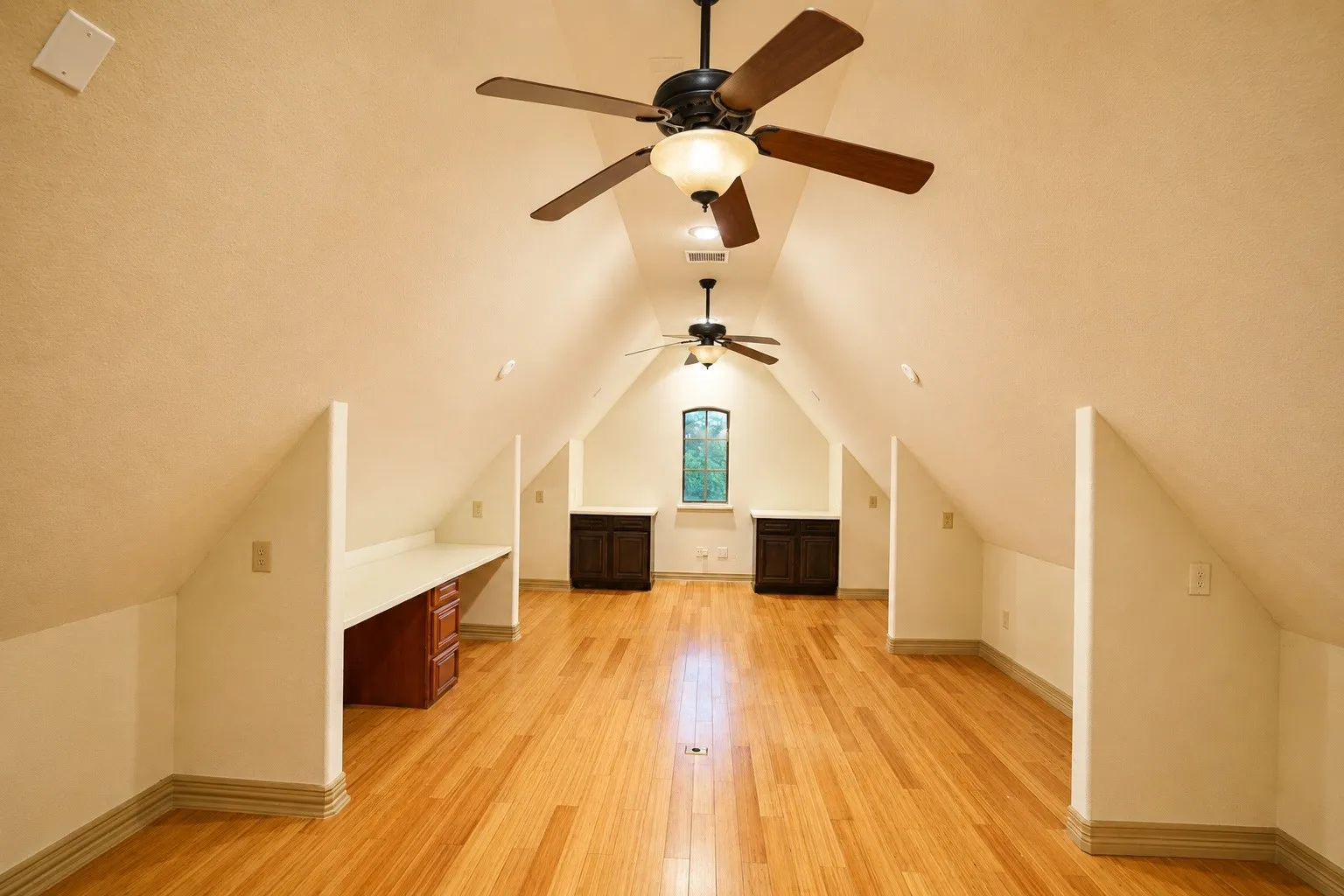 Hardwood flooring throughout, multiple ceiling fans, built-in desk with cabinetry, and additional built-in storage cabinets