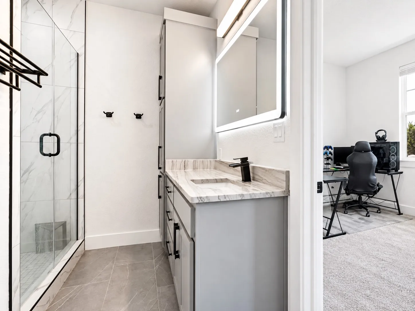 The studio bathroom features a spacious glass-enclosed walk-in shower, generous vanity storage, large WIC.