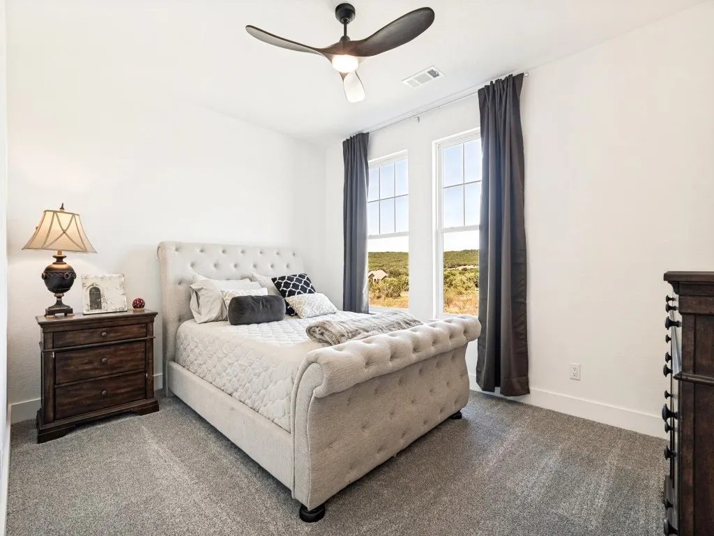 Recessed lighting, ceiling fan, twin window openings, and gray carpeting