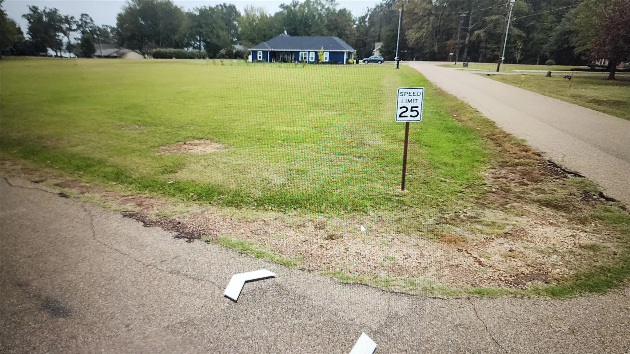 Expansive grass lot featuring a paved road frontage