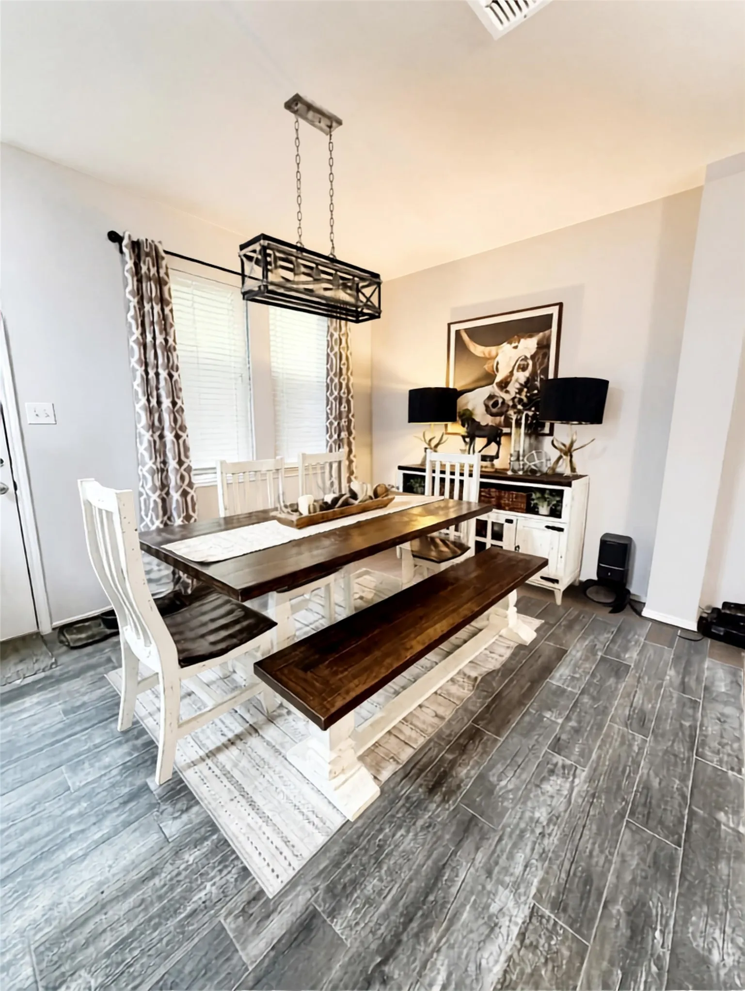 Wood-finish flooring, recessed lighting, and a linear chandelier illuminate this space