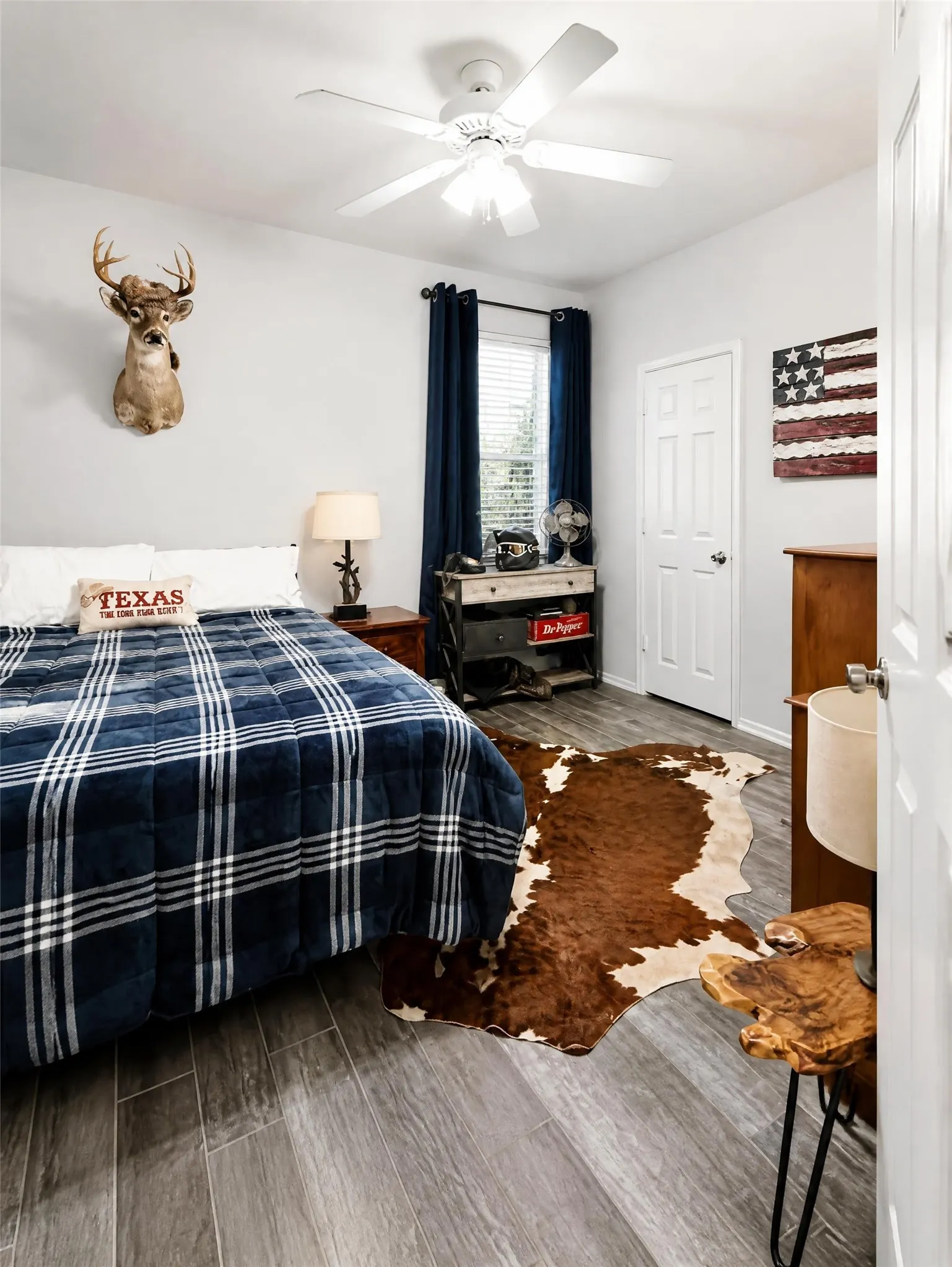 Wood-finish flooring, white ceiling fan, window with blinds, and paneled interior door