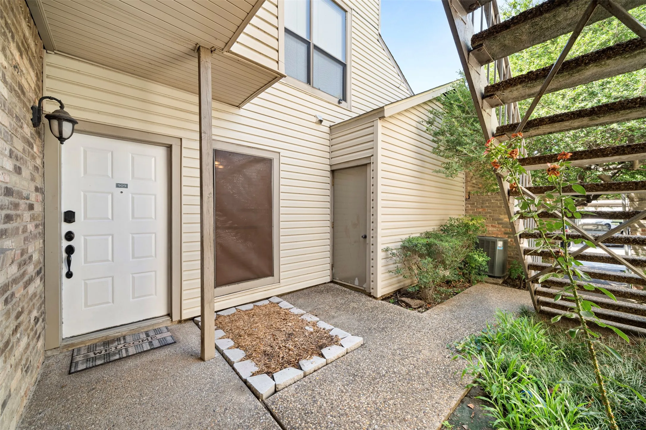 Entryway featuring a paneled door, brick exterior, and an outdoor wall sconce