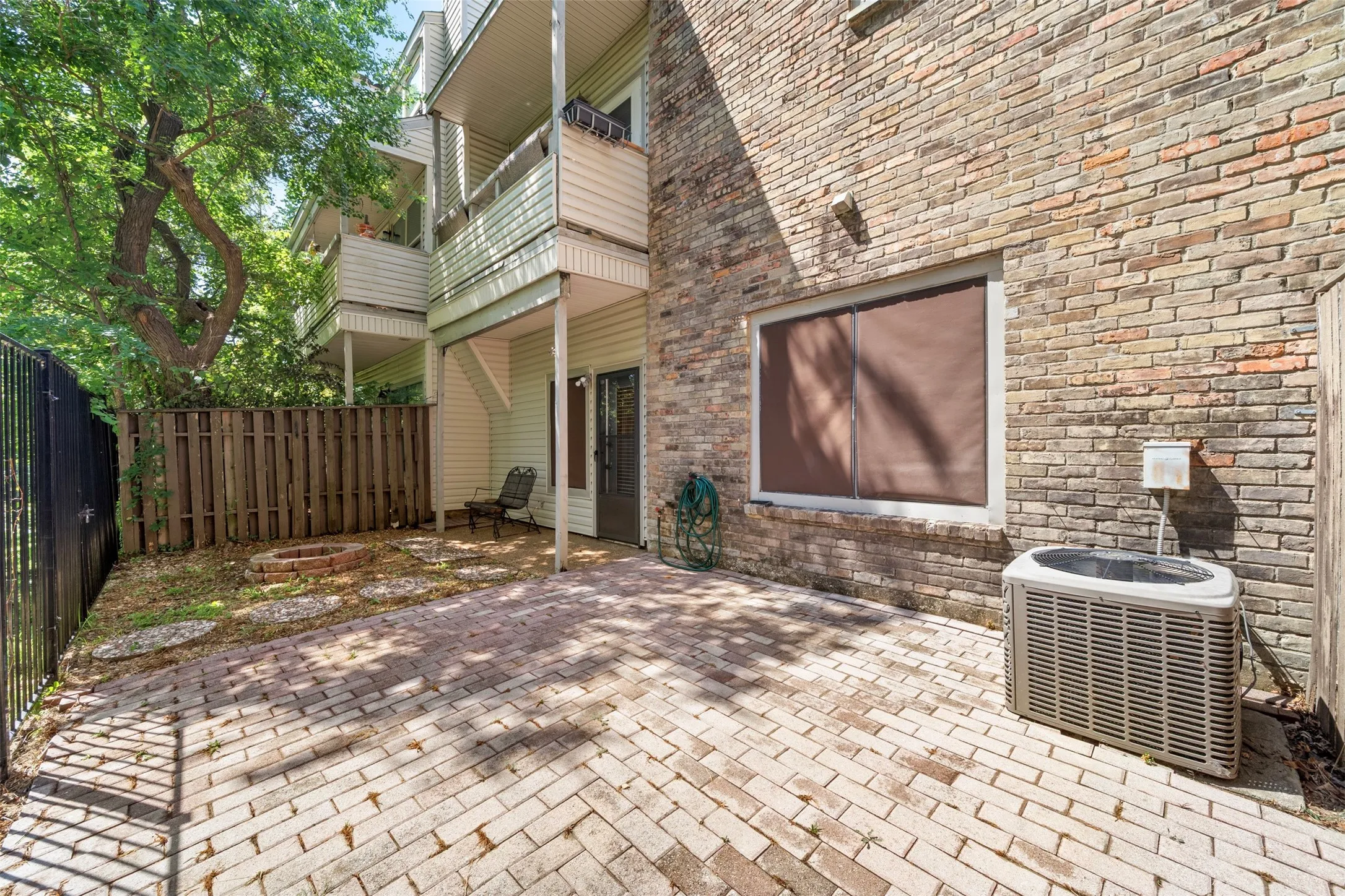 Brick exterior with a ground-level patio featuring a paver surface