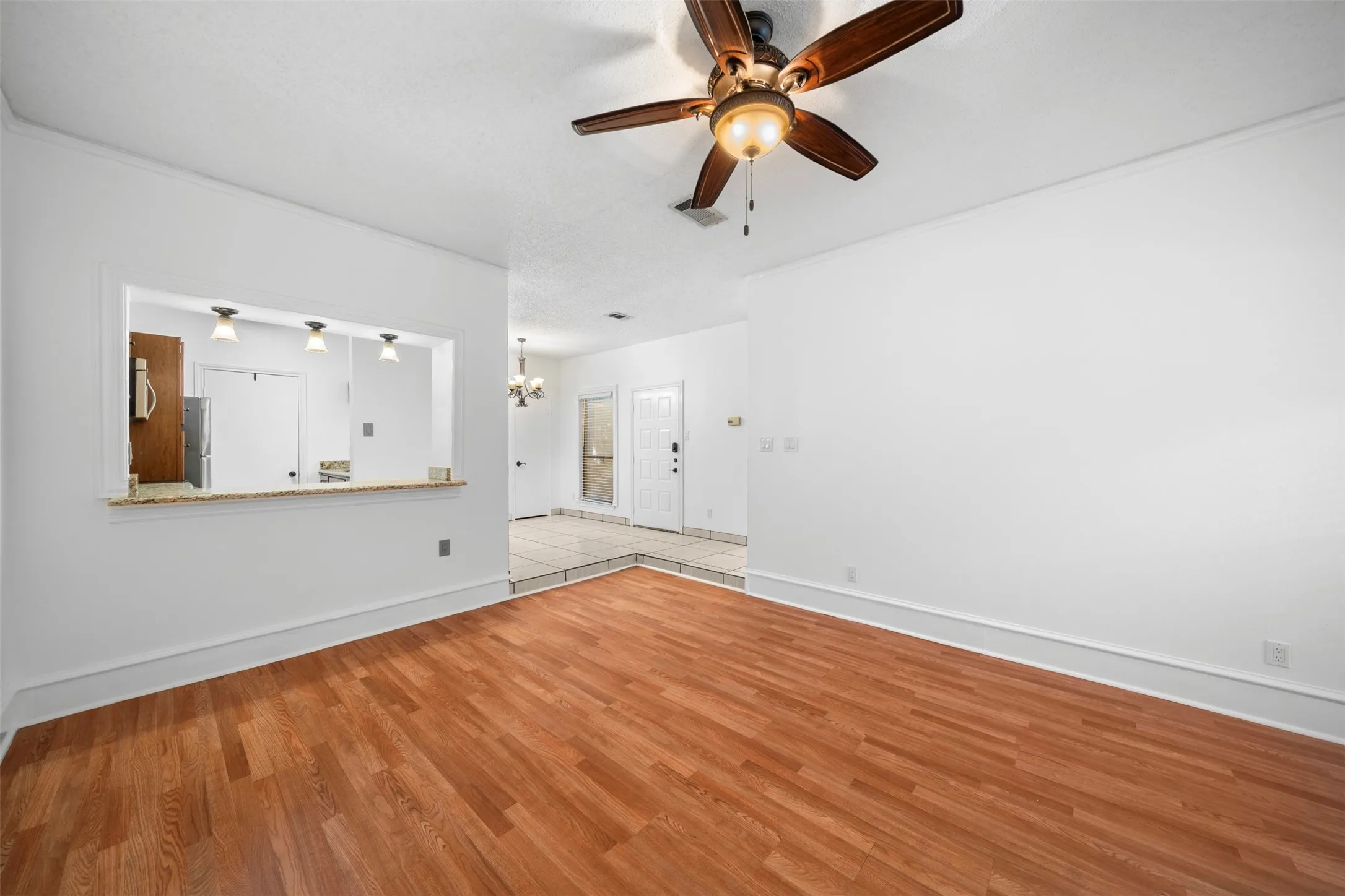 Wood-finish flooring with a pass-through window to the kitchen