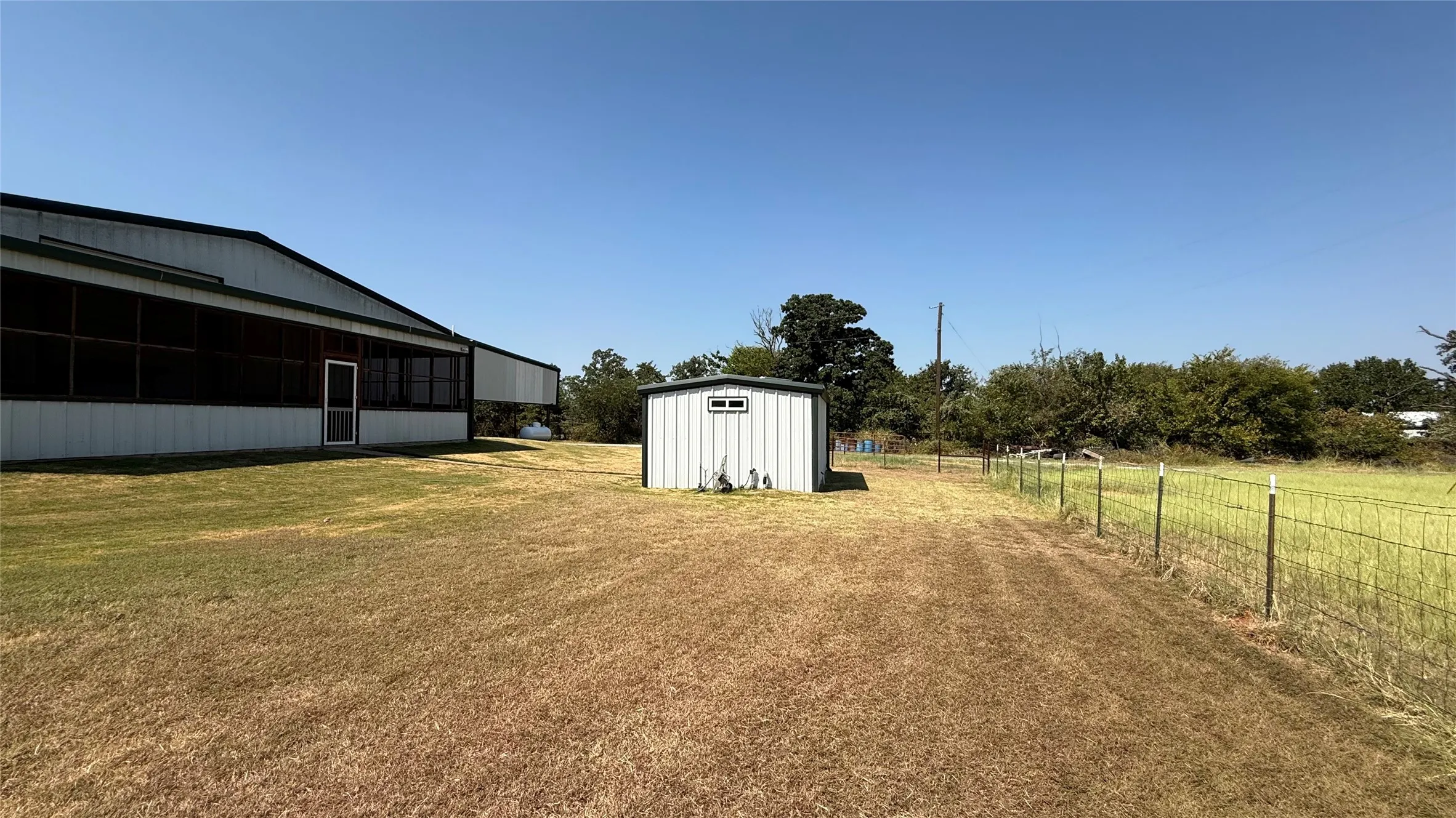 Metal-clad building with a screened porch and a separate utility shed