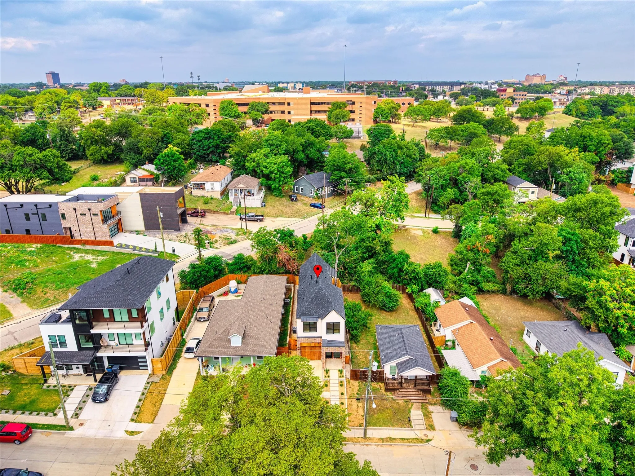 Aerial perspective of a neighborhood featuring a mix of architectural styles, mature trees, and varied lot sizes